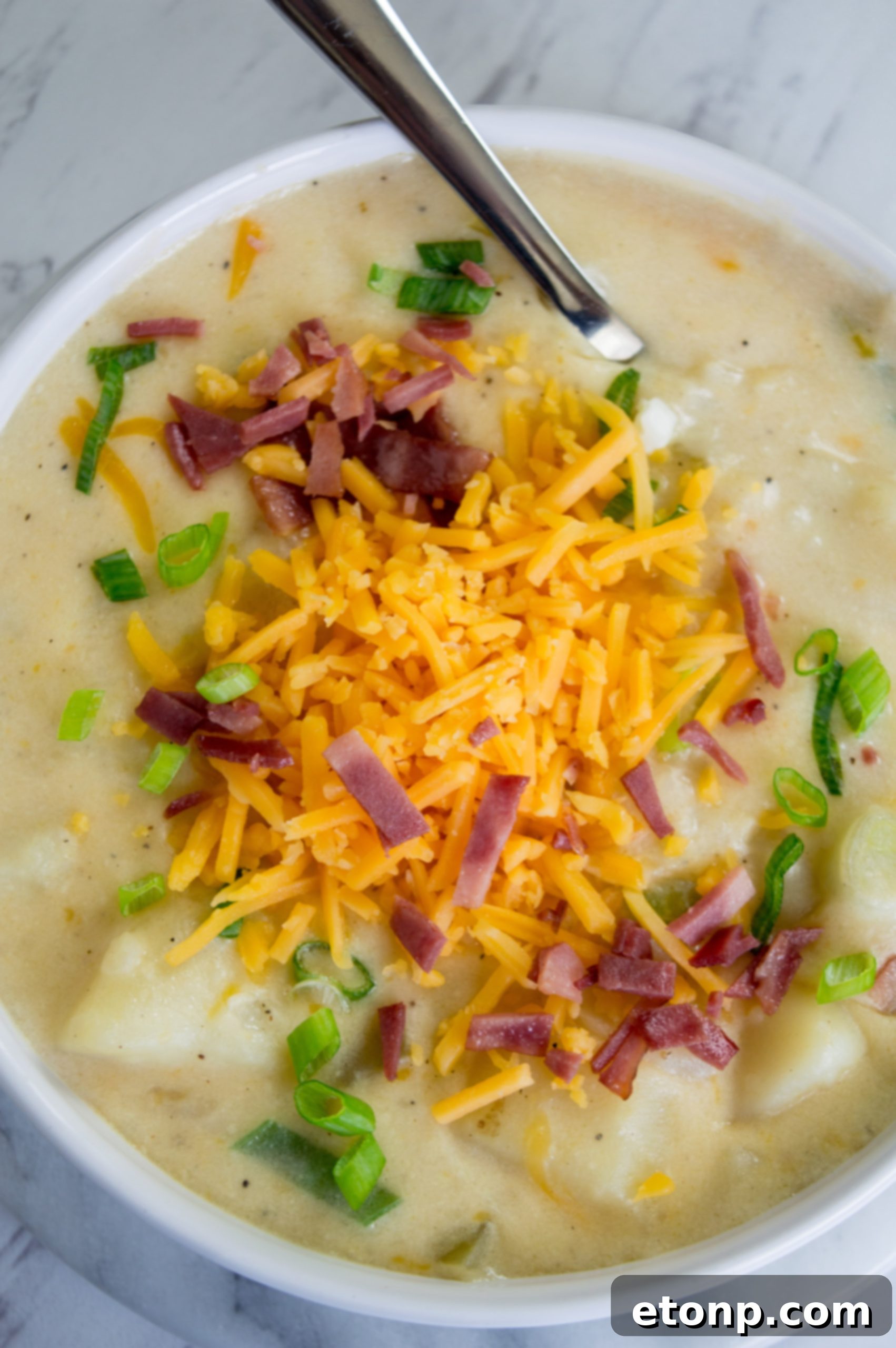 Ultimate Comfort Potato Soup 5 Another perspective of a bowl of loaded potato soup, highlighting the generous amount of toppings and the rich texture.