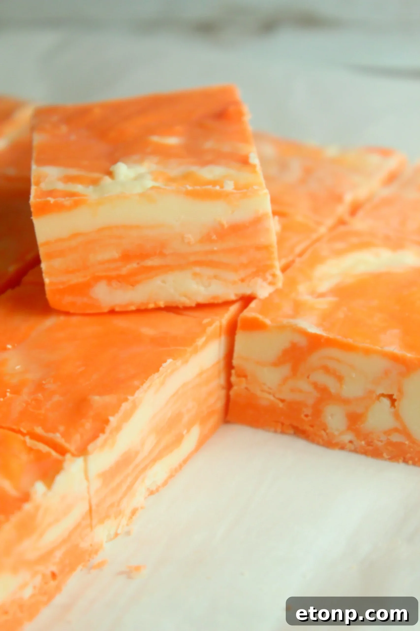 Easy No Bake Orange Creamsicle Fudge 6 Several neatly cut squares of orange creamsicle fudge arranged, ready for serving.