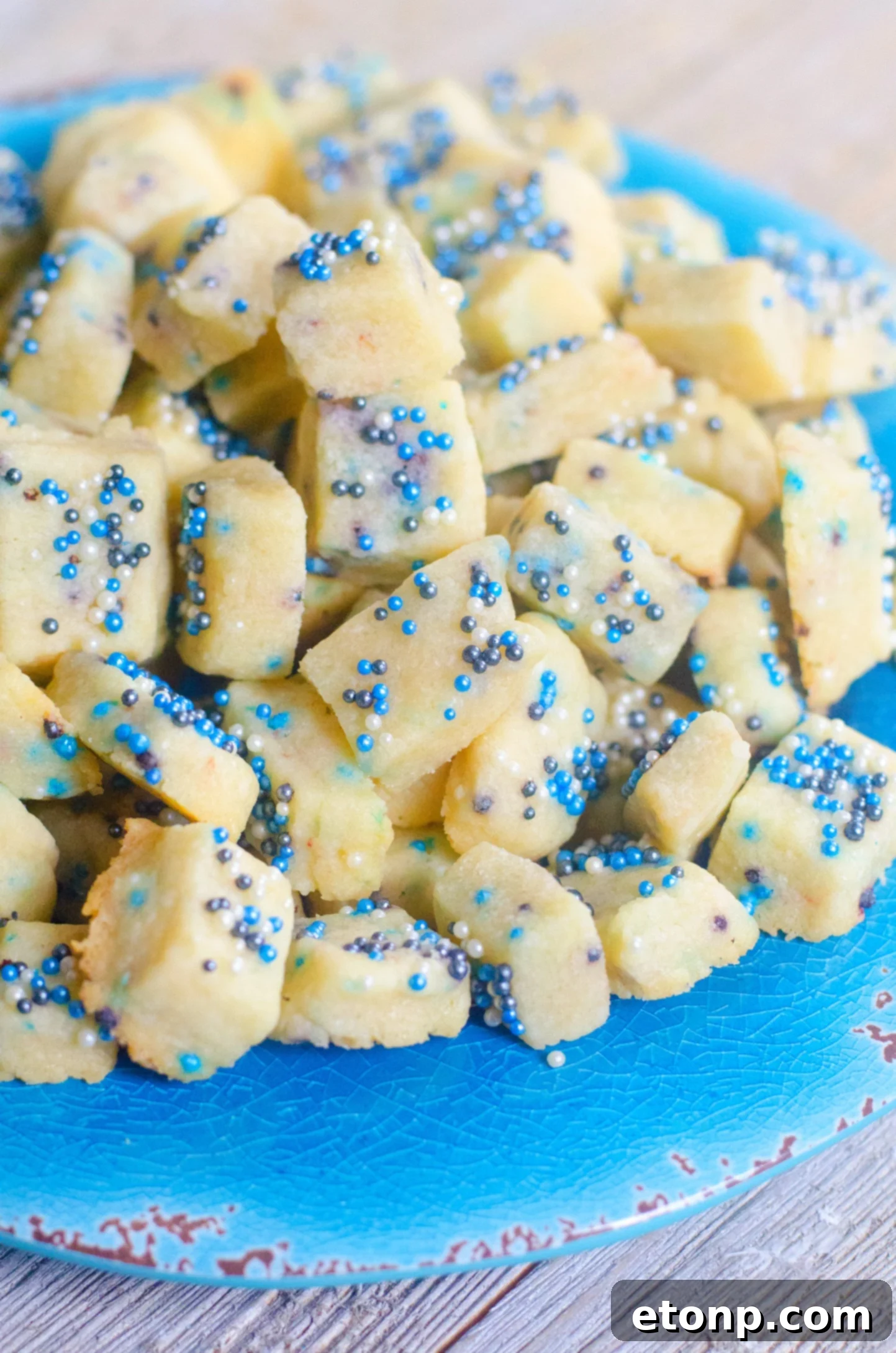 Delicious Winter Shortbread Bites with colorful sprinkles, artfully arranged on a rustic wooden surface.