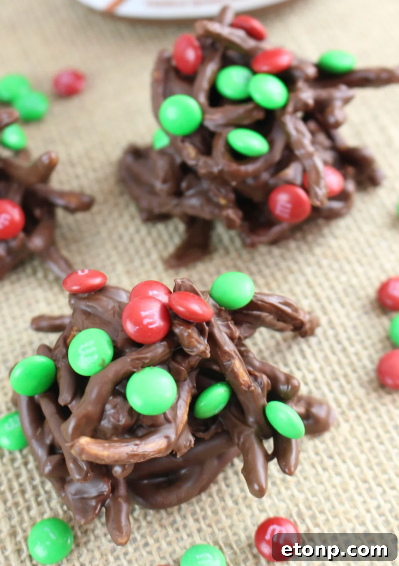 A festive holiday chocolate haystack dessert on a plate, adorned with red and green M&M's.