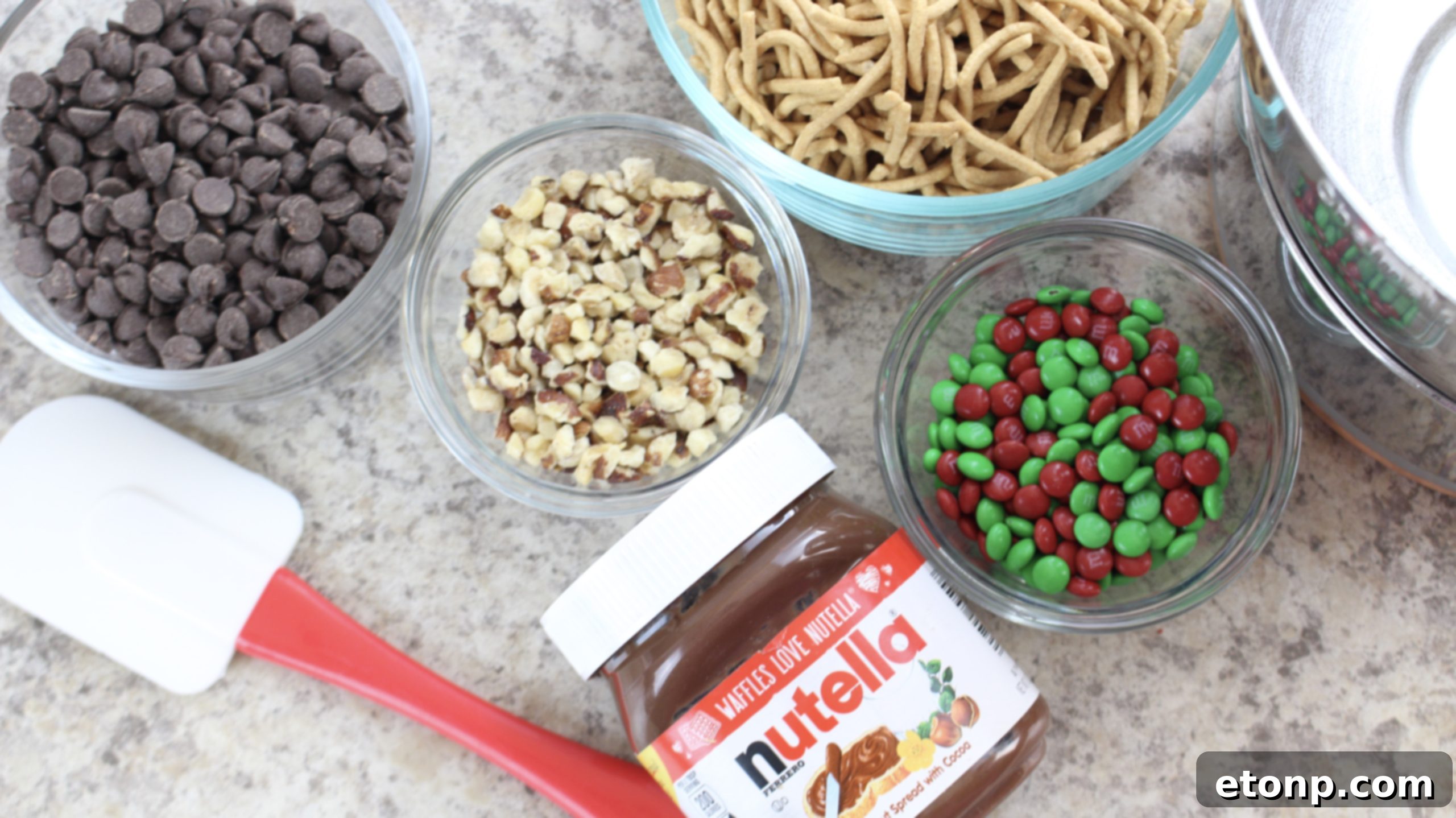 Close-up of holiday chocolate haystacks with colorful M&M's on a white platter.