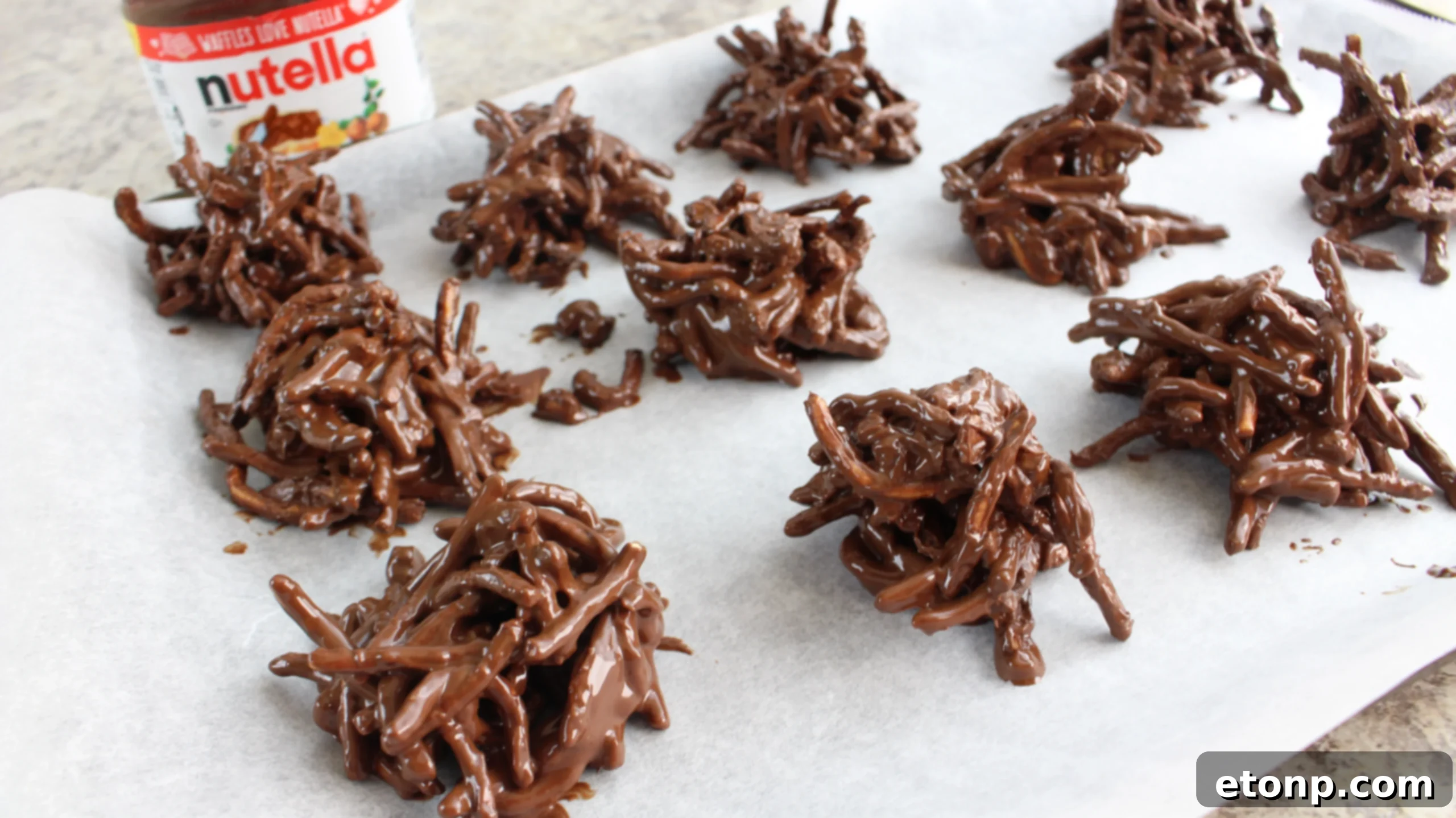Melted chocolate and Nutella being poured over chow mein noodles in a large mixing bowl.