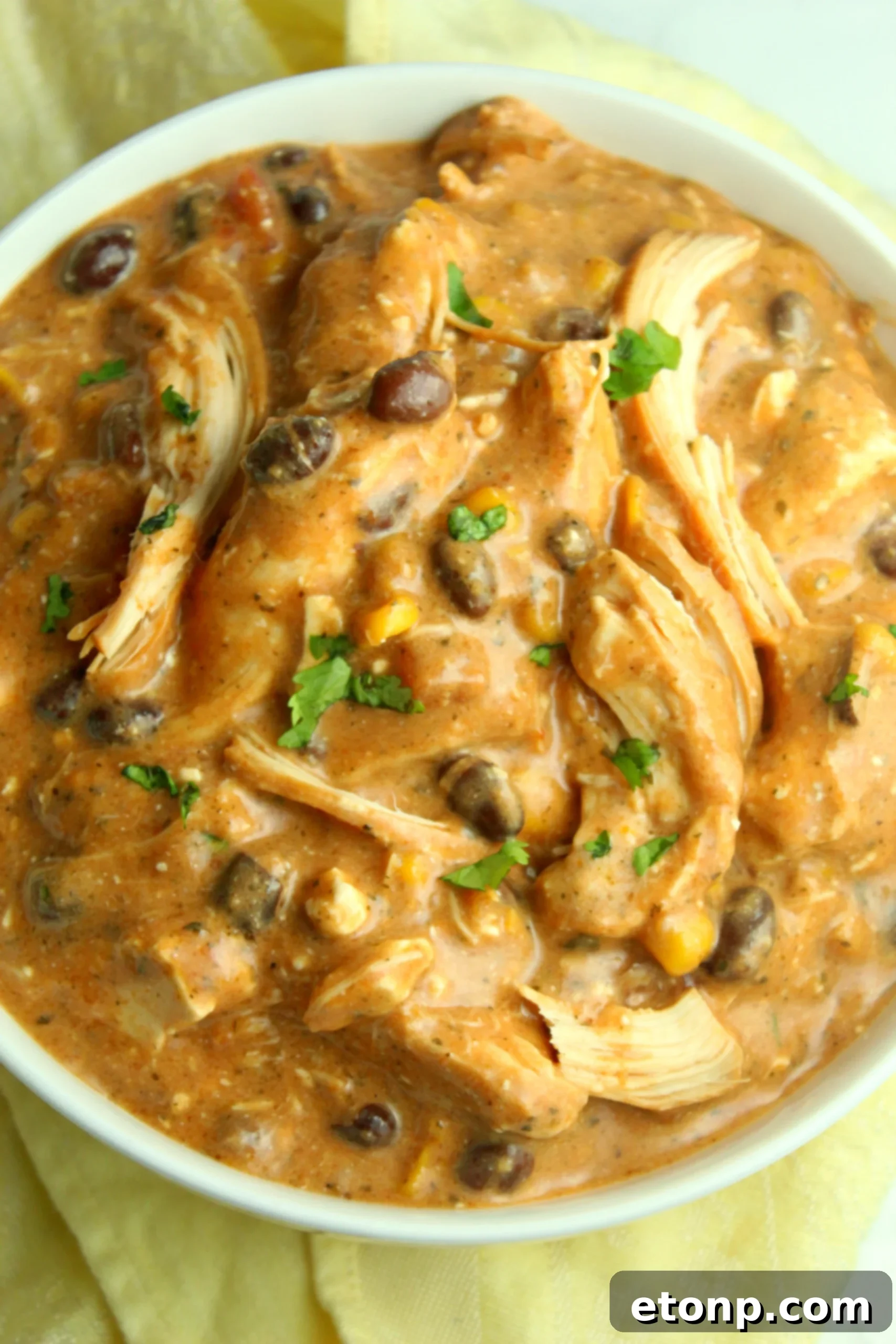 Creamy Slow Cooker Chicken Chili with Cream Cheese 6 Close-up of the chicken chili simmering in the slow cooker, showing the bubbling sauce and tender chicken pieces.