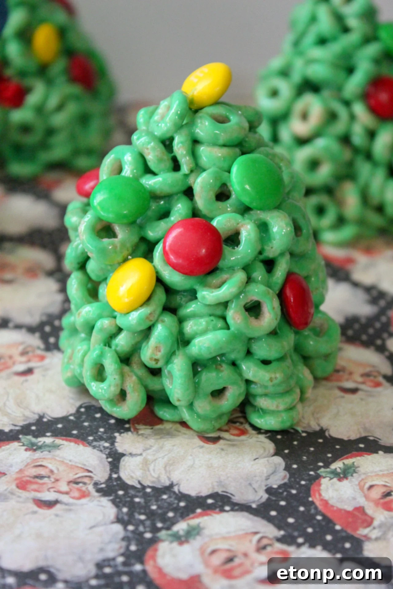 Close-up of a festive Cheerio Christmas Tree Treat with green color and M&M decorations.