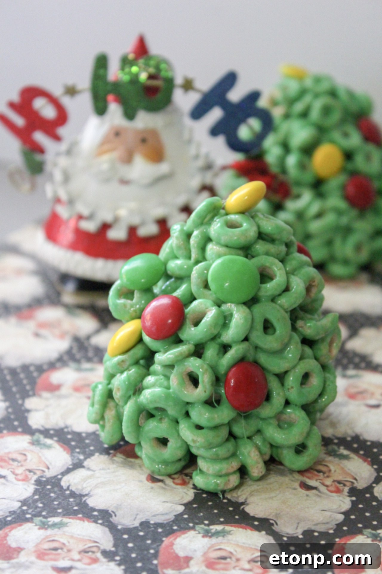 A collection of Cheerio Christmas Tree Treats, some with red and green M&Ms, one with a yellow star.