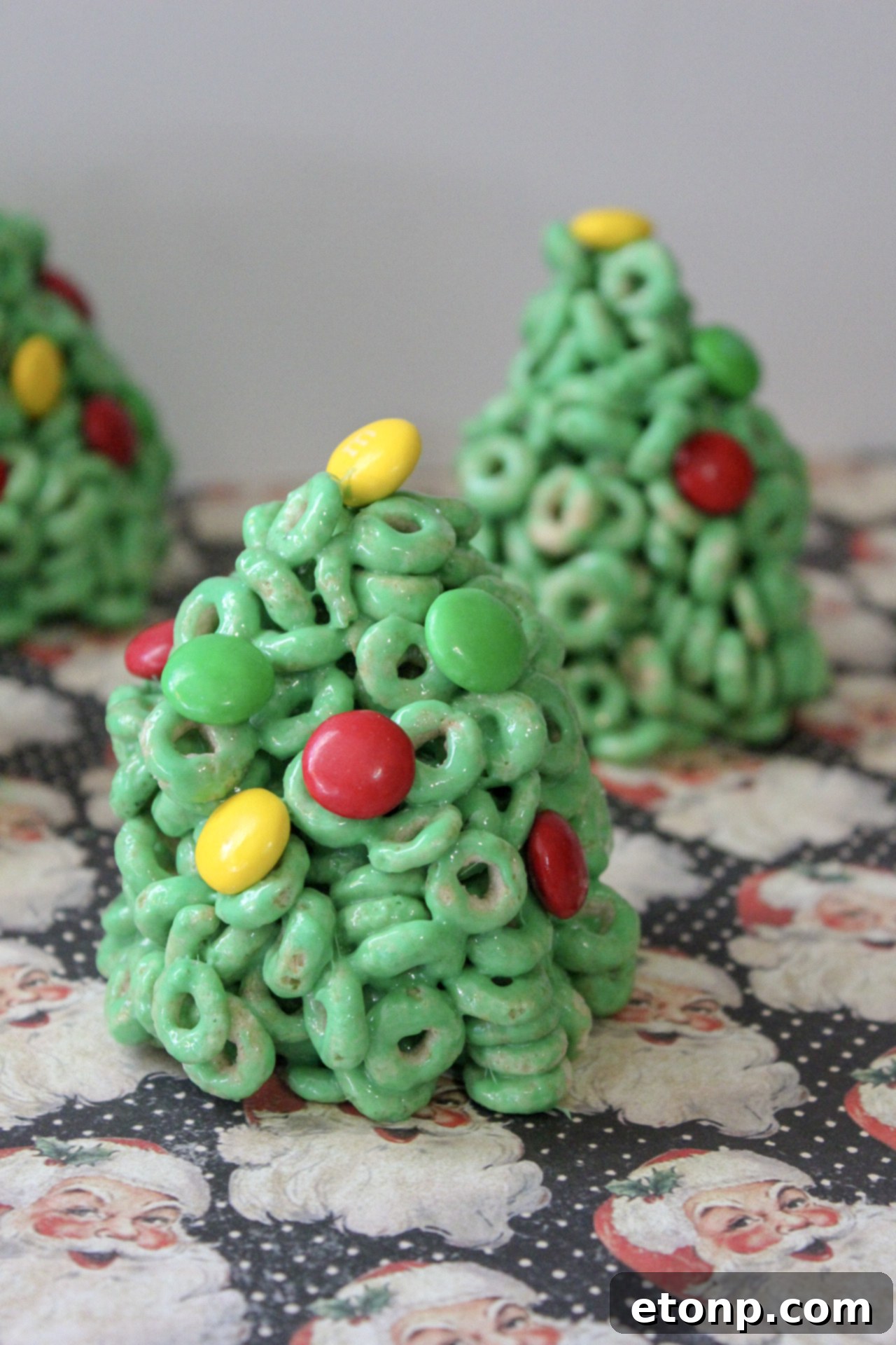 A close-up shot of a single Cheerio Christmas Tree Treat with candy decorations.