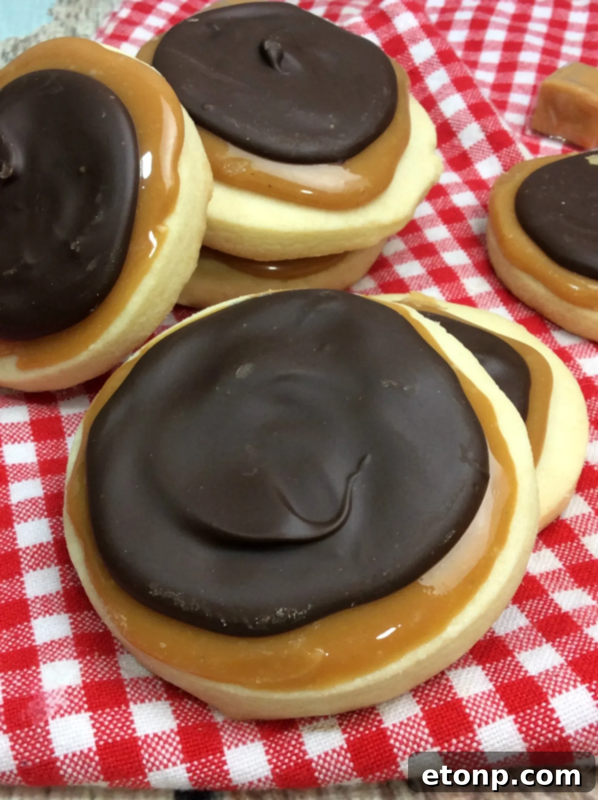 Copycat Twix Cookies 2 Close-up of a stack of Homemade Twix Cookies showing the buttery shortbread, chewy caramel, and glossy chocolate layers.
