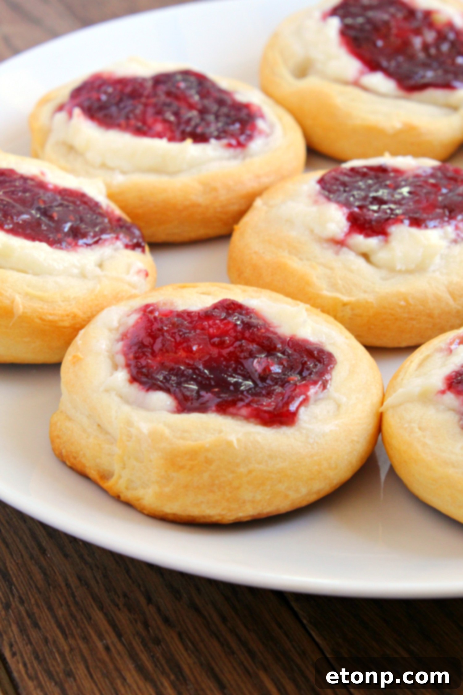 Luscious Raspberry Cream Cheese Crescents 3 Overhead shot of a tray of unbaked Raspberry Cream Cheese Crescent Danishes, showing the dough circles with cream cheese and raspberry fillings before baking.