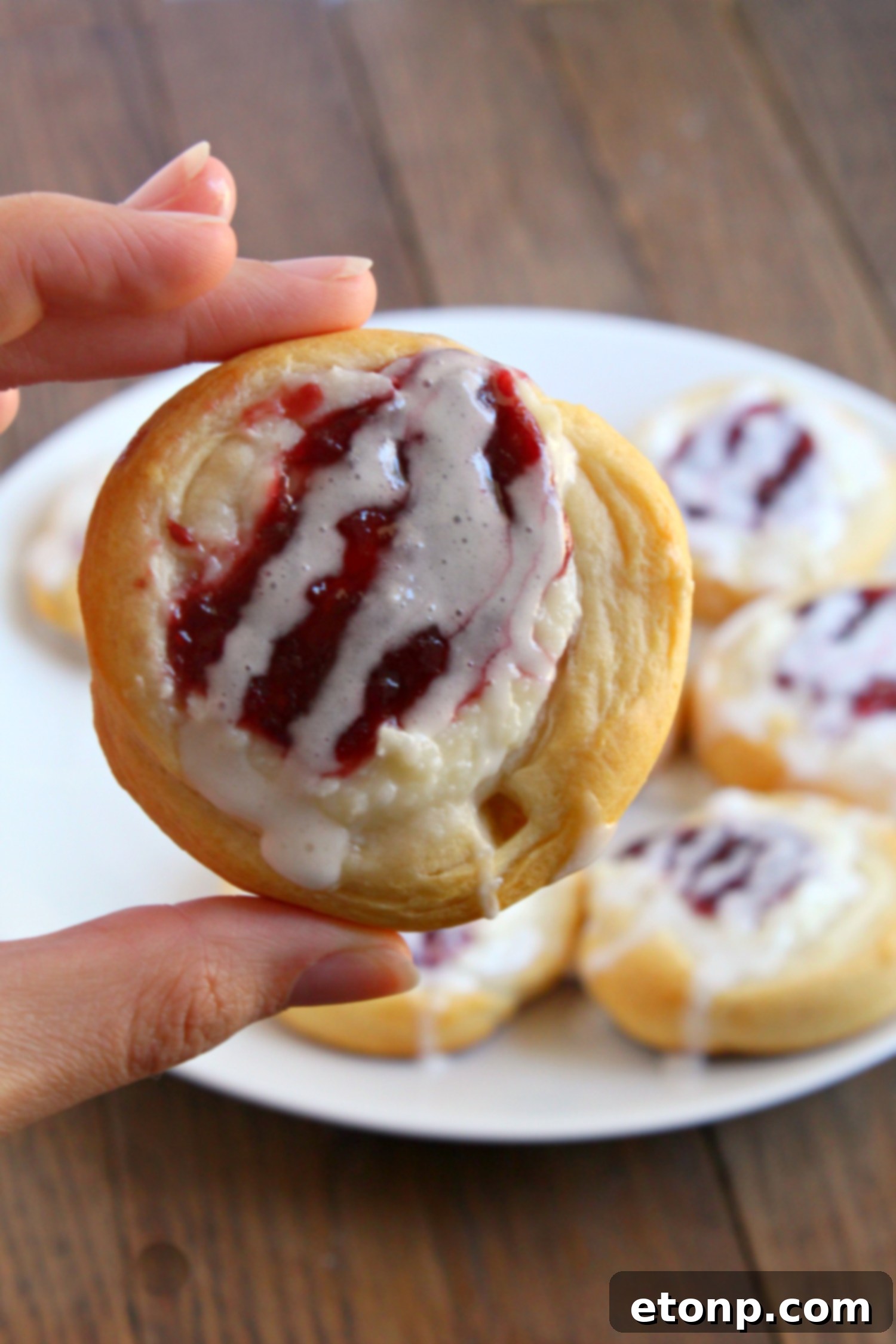 Luscious Raspberry Cream Cheese Crescents 8 A stack of Raspberry Cream Cheese Crescent Danishes on a cutting board, ready to be served.