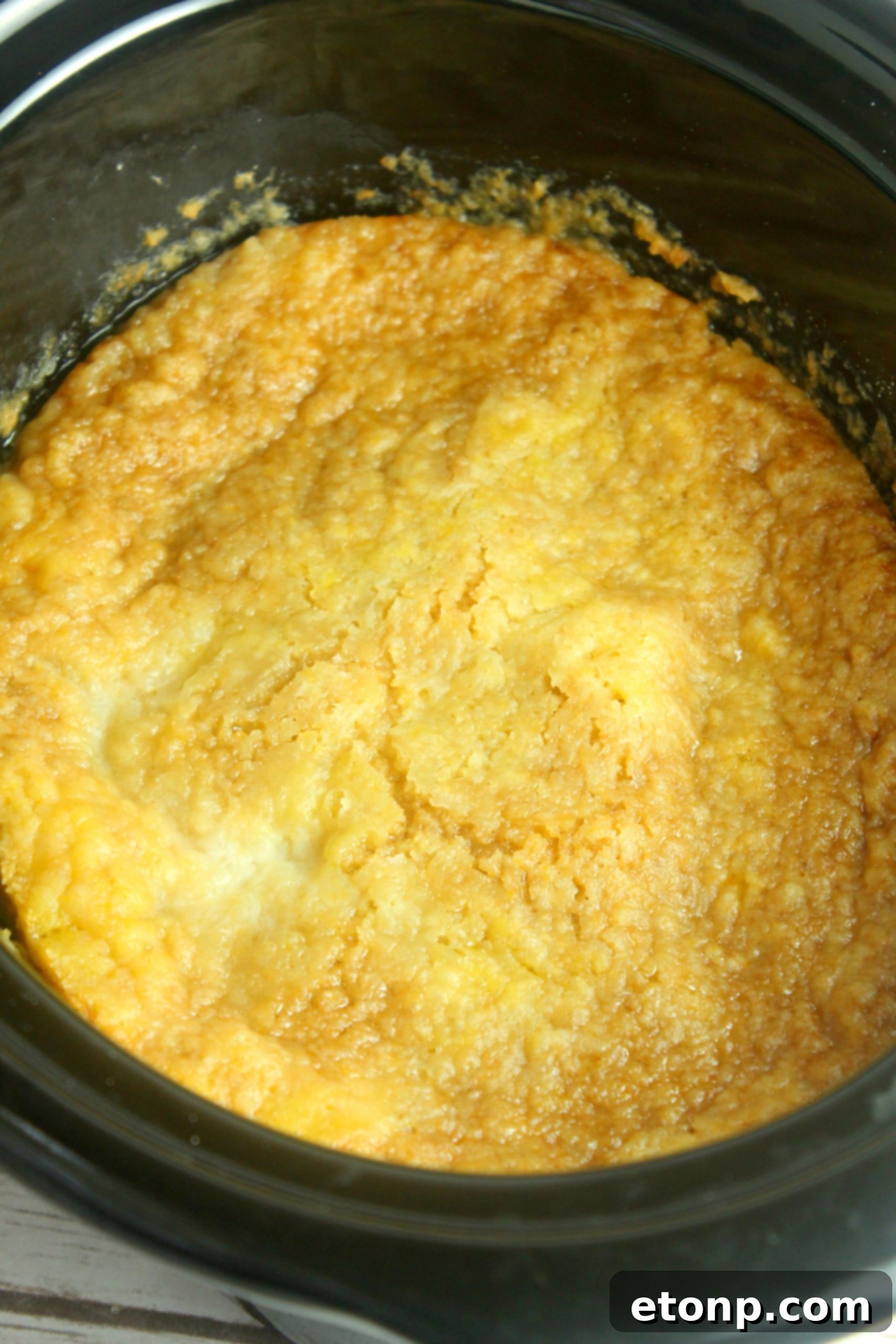 Close-up view of golden brown slow cooker peach cobbler with a hint of cinnamon