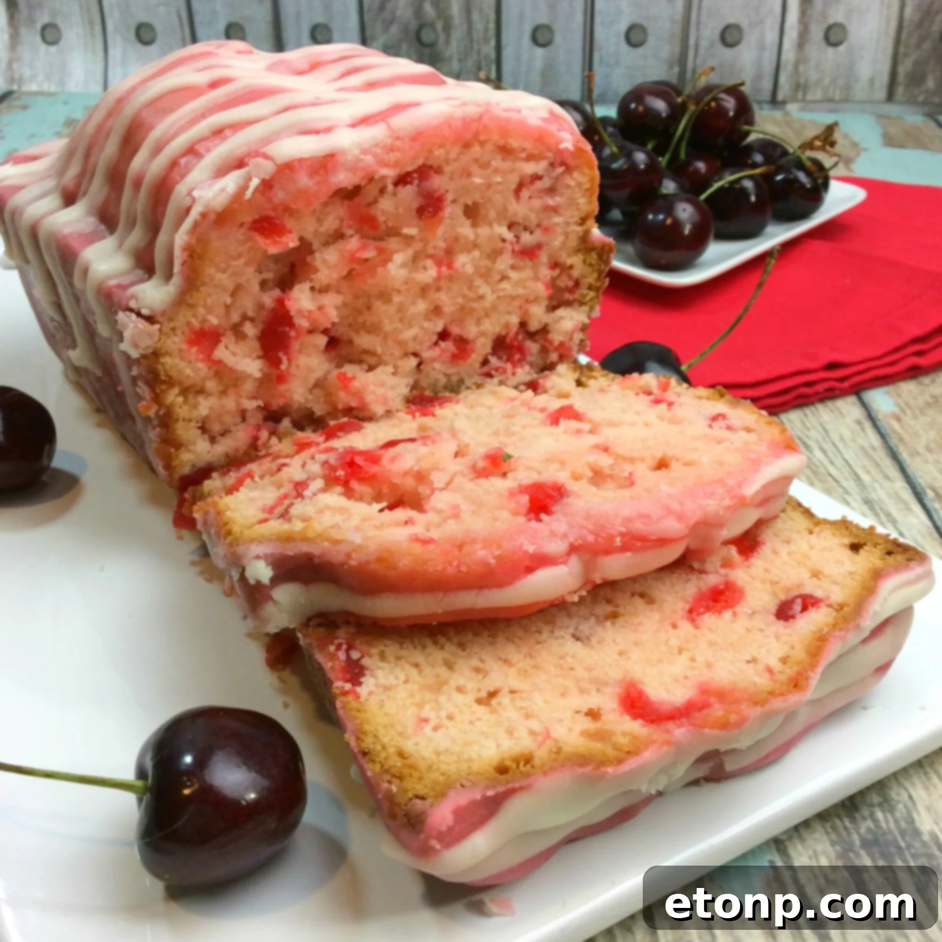 A different angle of the Cherry Garcia Loaf Cake, showcasing its beautiful pink glaze and the subtle sheen of the cake itself.