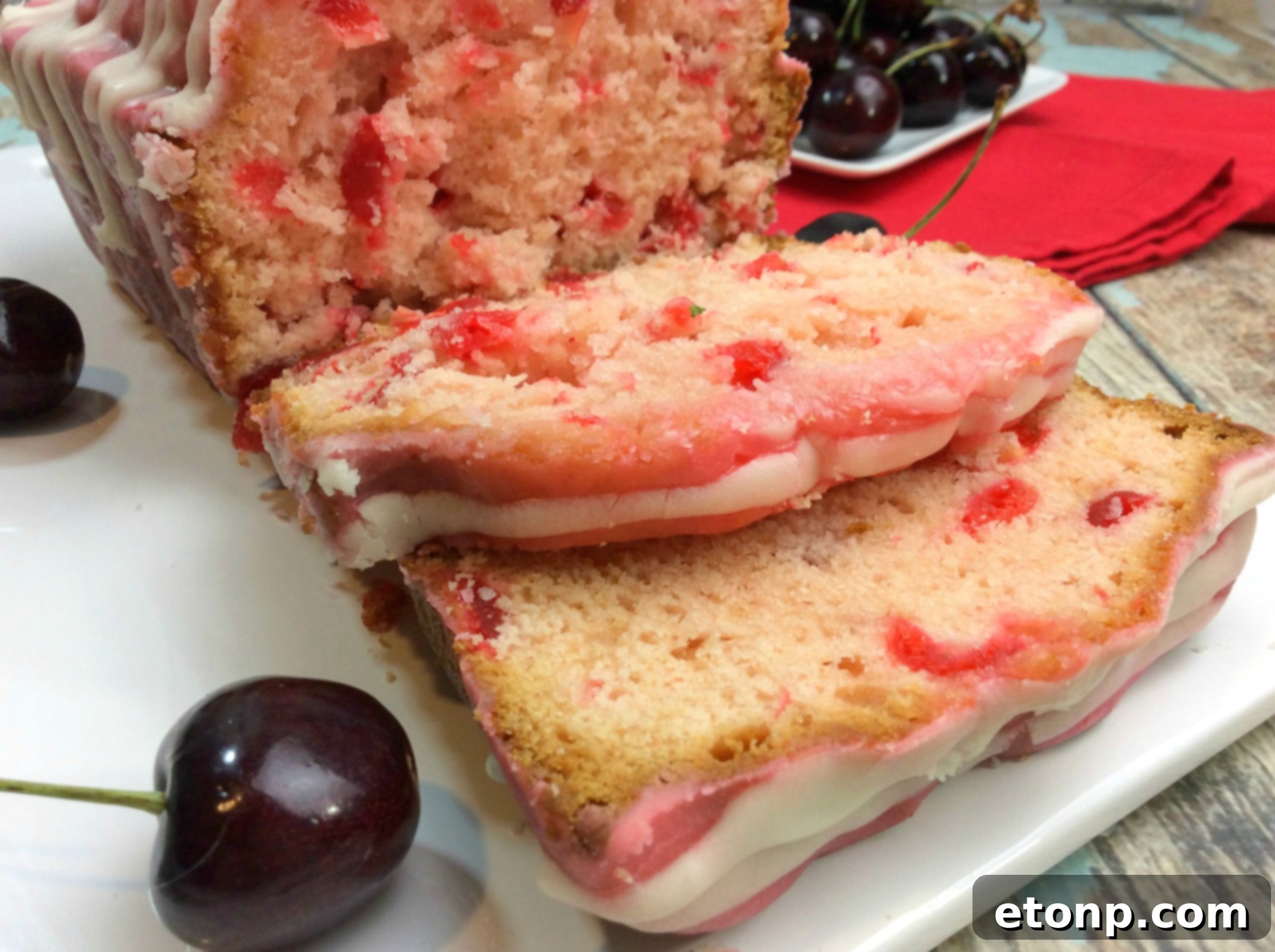 A close-up shot of a slice of Cherry Garcia Loaf Cake, perfectly glazed and ready to be enjoyed.