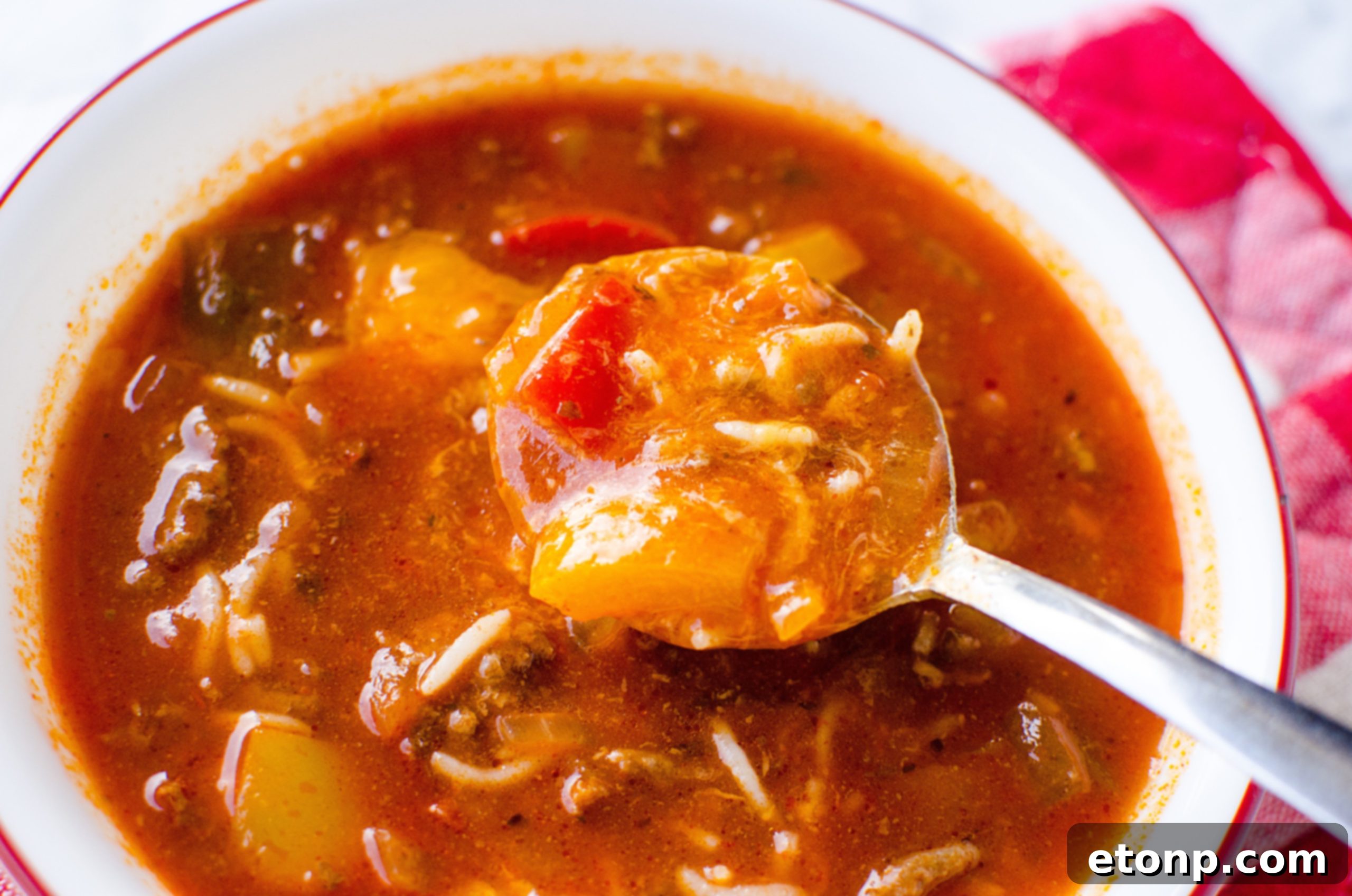 A large pot filled with Stuffed Pepper Soup simmering on the stove, steam rising, showcasing the rich texture.