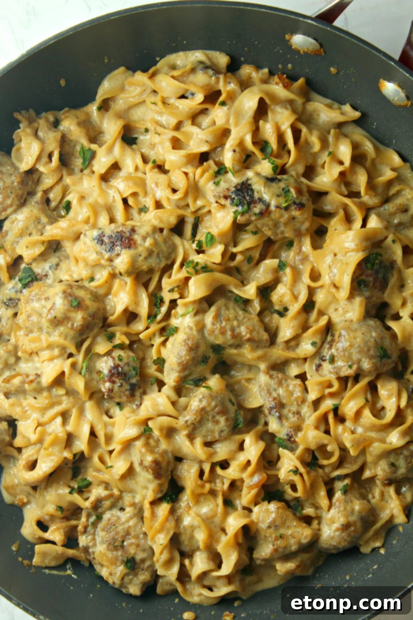 Close-up of Creamy French Onion Sausage Pasta with delicious gooey cheese