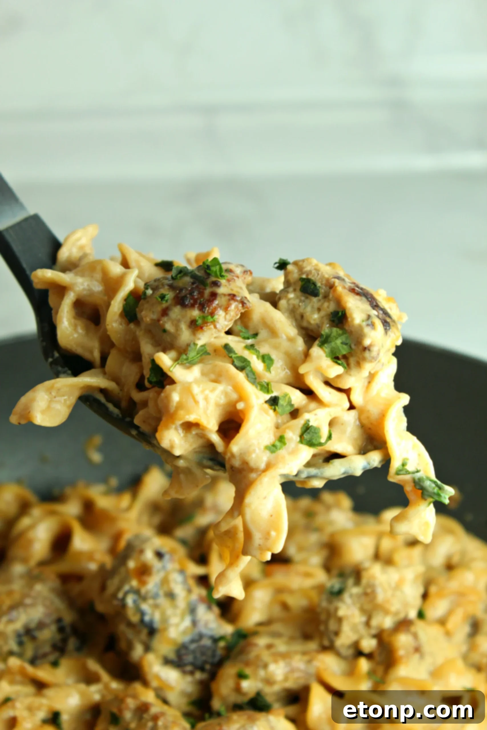 A steaming bowl of Creamy French Onion Sausage Pasta, ready to be enjoyed