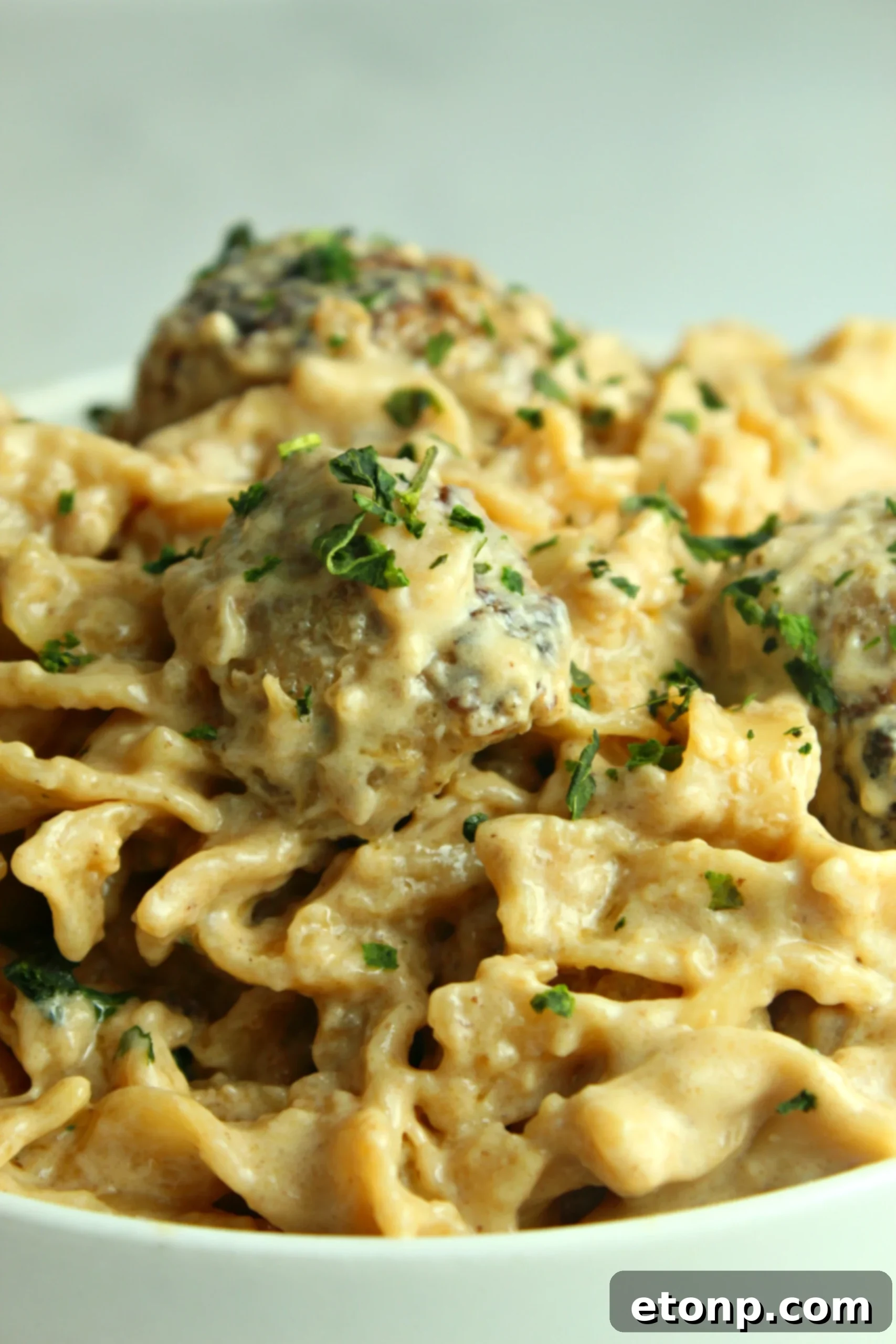 Overhead shot of Creamy French Onion Sausage Pasta with a fork taking a bite