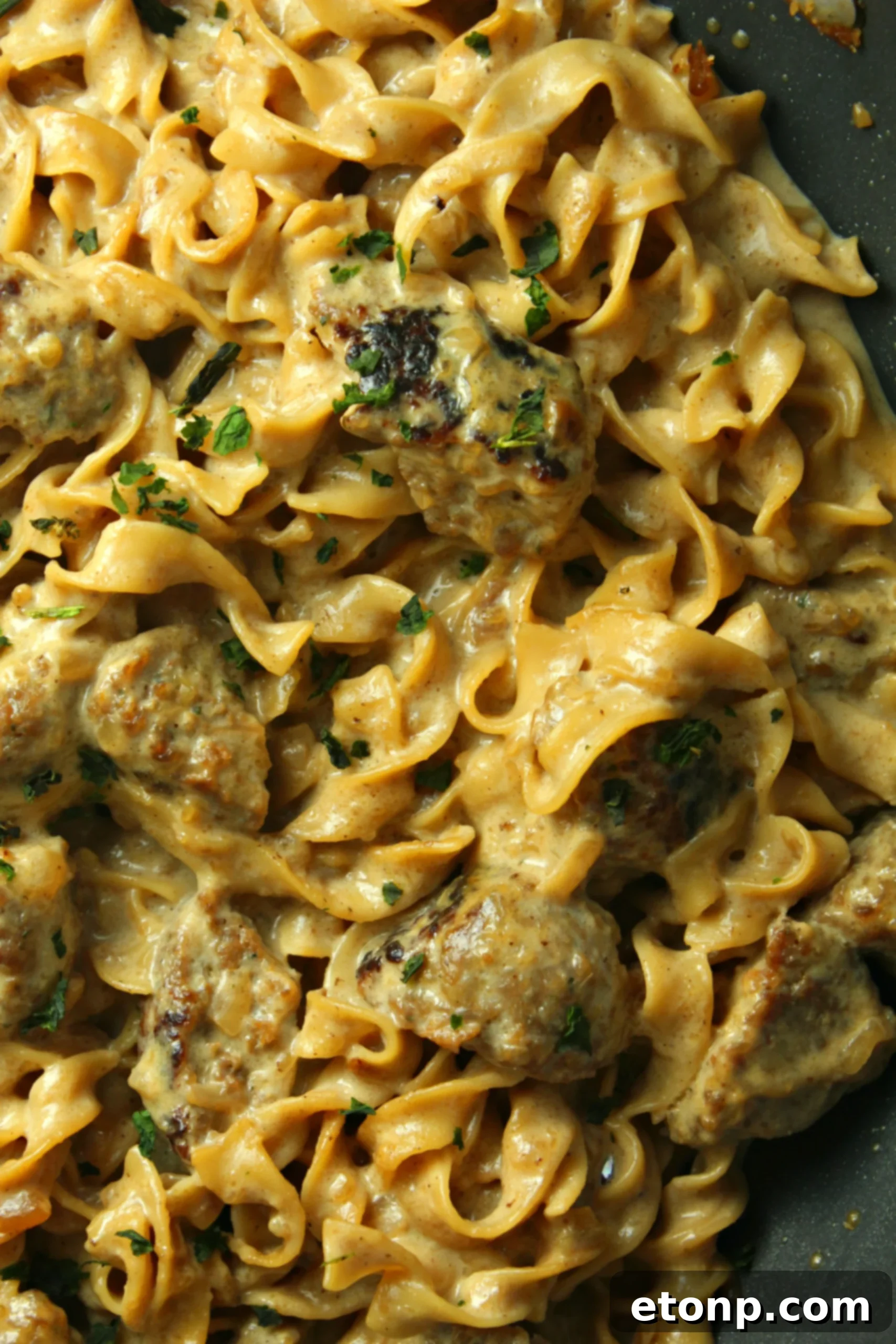 Creamy French Onion Sausage Pasta in a decorative bowl with fresh herbs