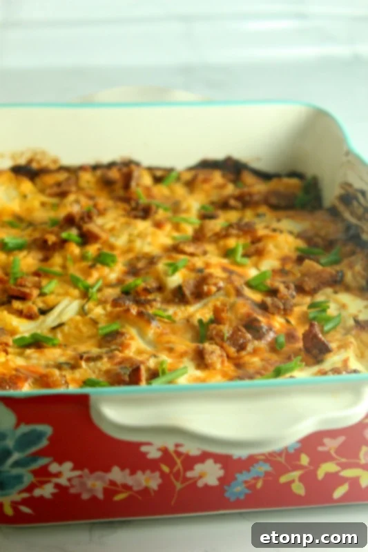 A close-up overhead shot of the baked Loaded Cheesy Cauliflower Casserole, showcasing its rich texture and topping.