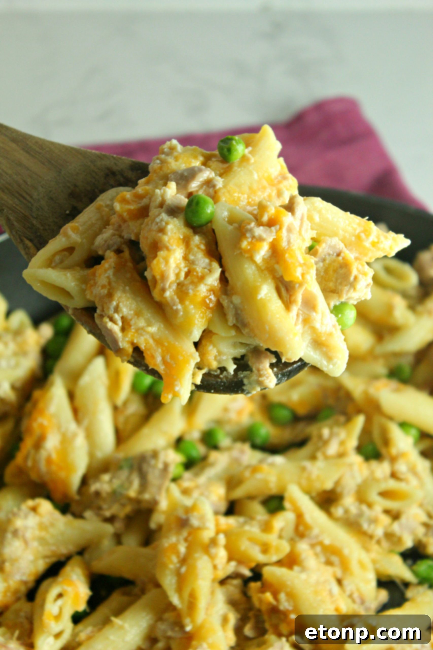 A serving of Cheesy Tuna Casserole on a plate, paired with crusty garlic bread