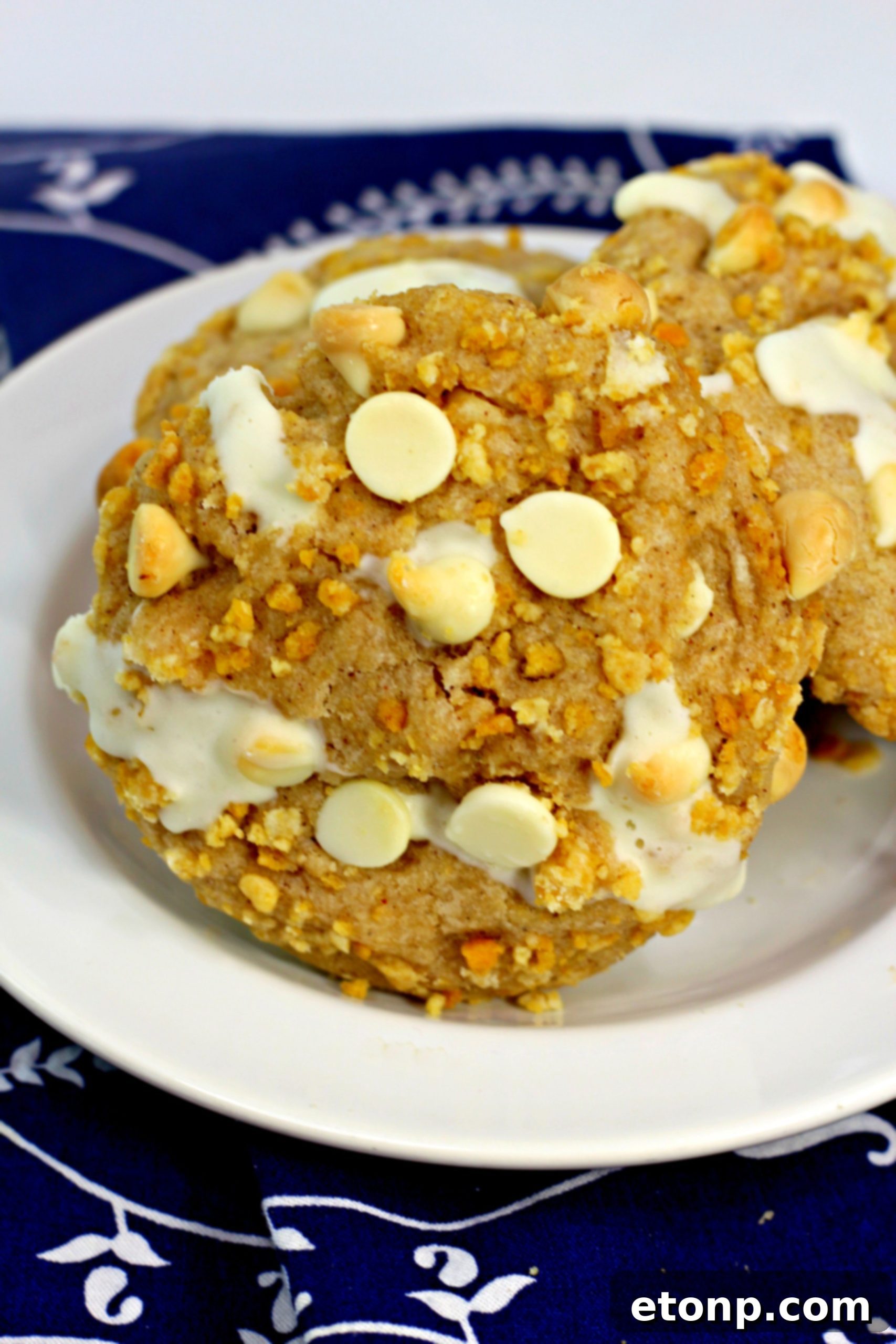 Cinnamon Roll Stuffed Cookies stacked neatly on a cooling rack, glistening with frosting