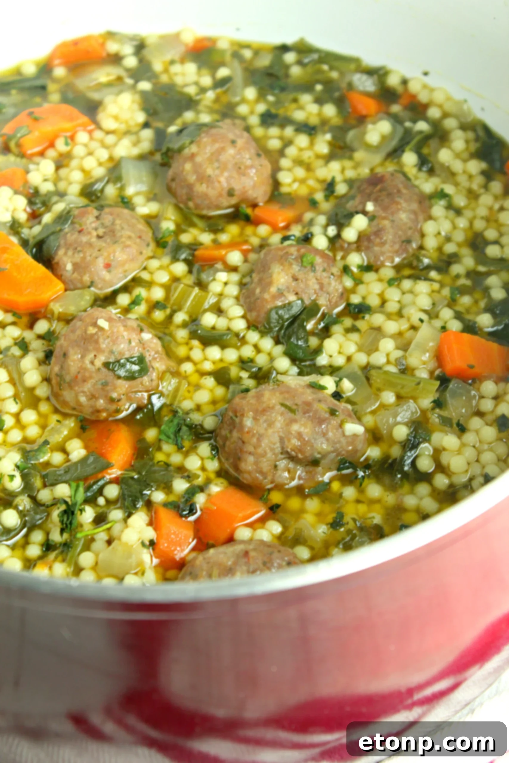 A bowl of delicious Italian Wedding Soup with small meatballs, pasta, and green vegetables, ready to be enjoyed.