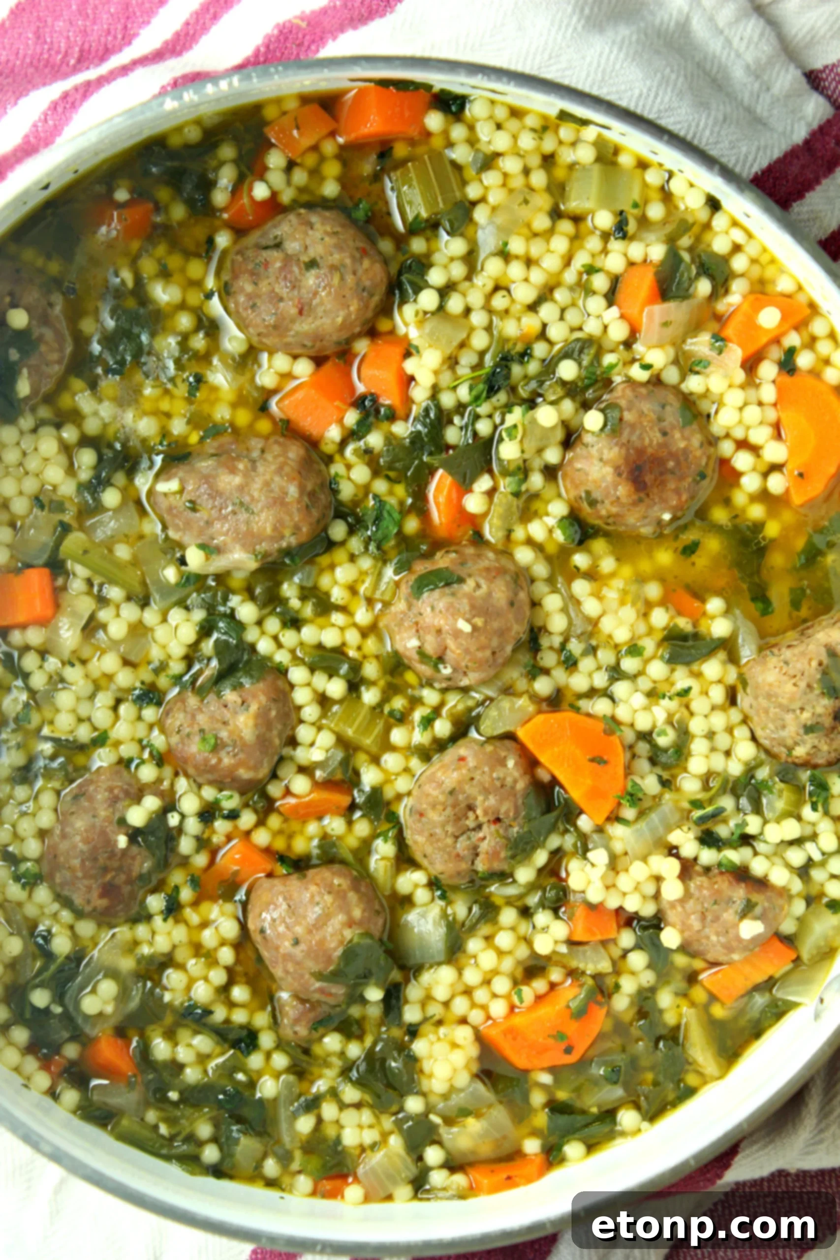 Close-up of freshly rolled miniature meatballs, a key ingredient for authentic Italian Wedding Soup.