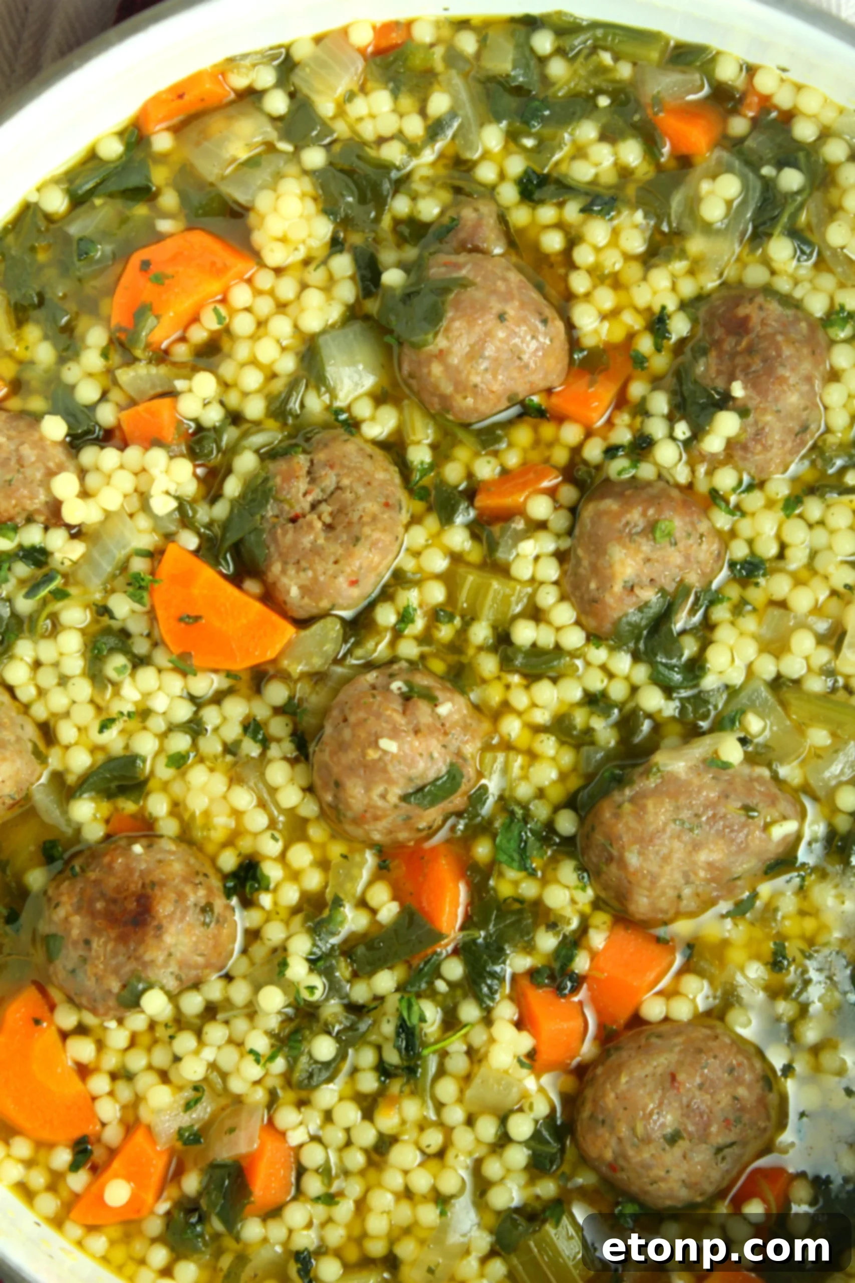 Small, round Acini de Pepe pasta, a key ingredient for authentic Italian Wedding Soup, shown in a measuring cup.