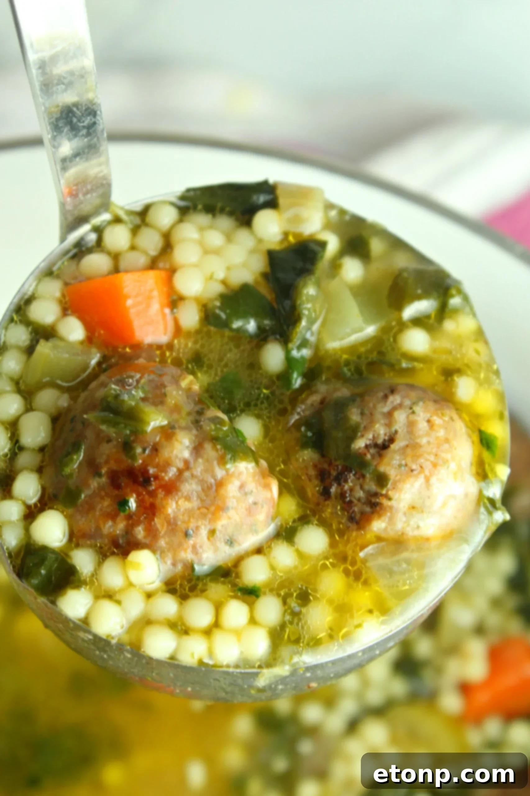 A close-up view of the simmering Italian Wedding Soup, highlighting the delicious homemade meatballs and rich broth.