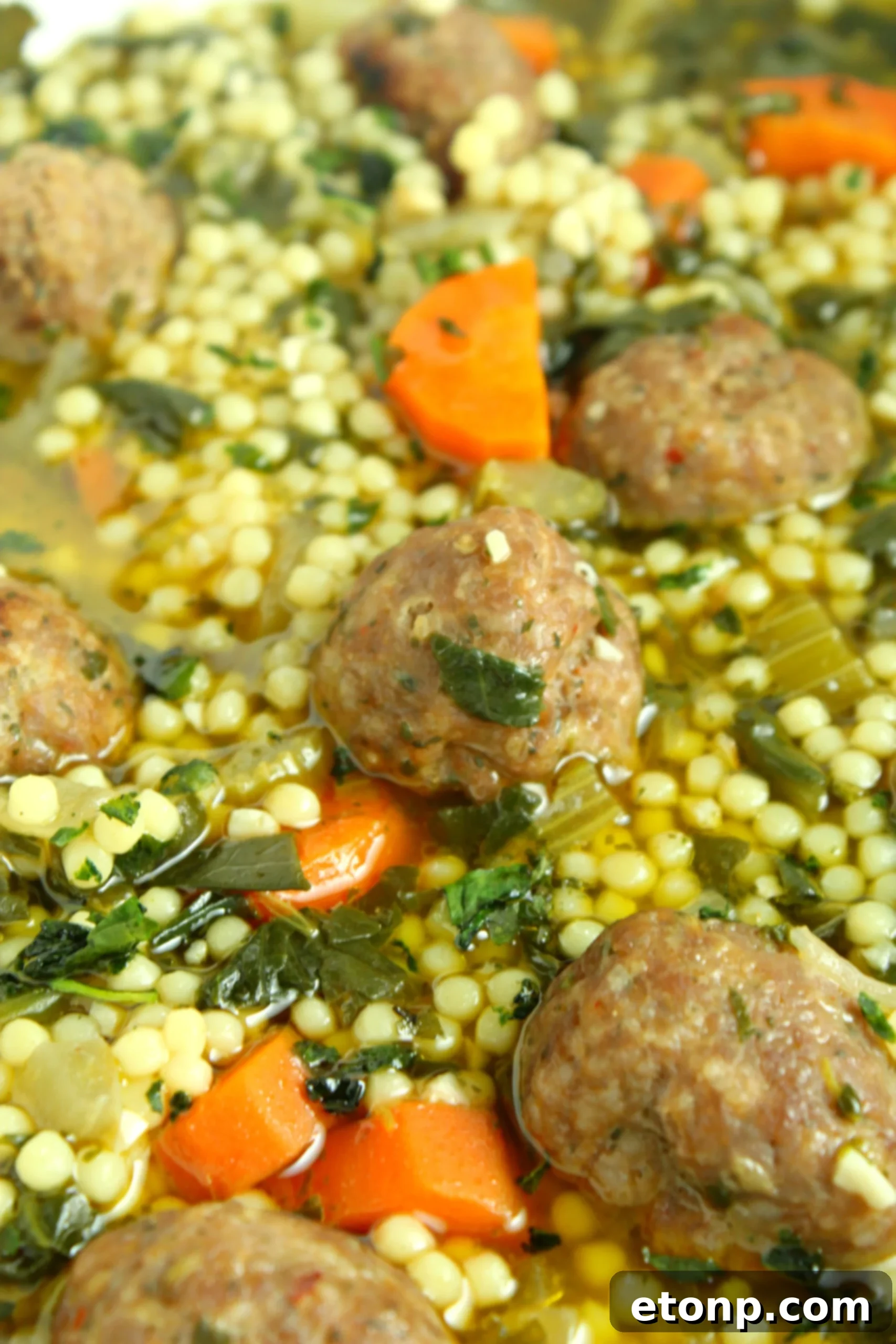 A cozy scene with a bowl of Italian Wedding Soup, accompanied by a slice of crusty bread, ready for a comforting meal.