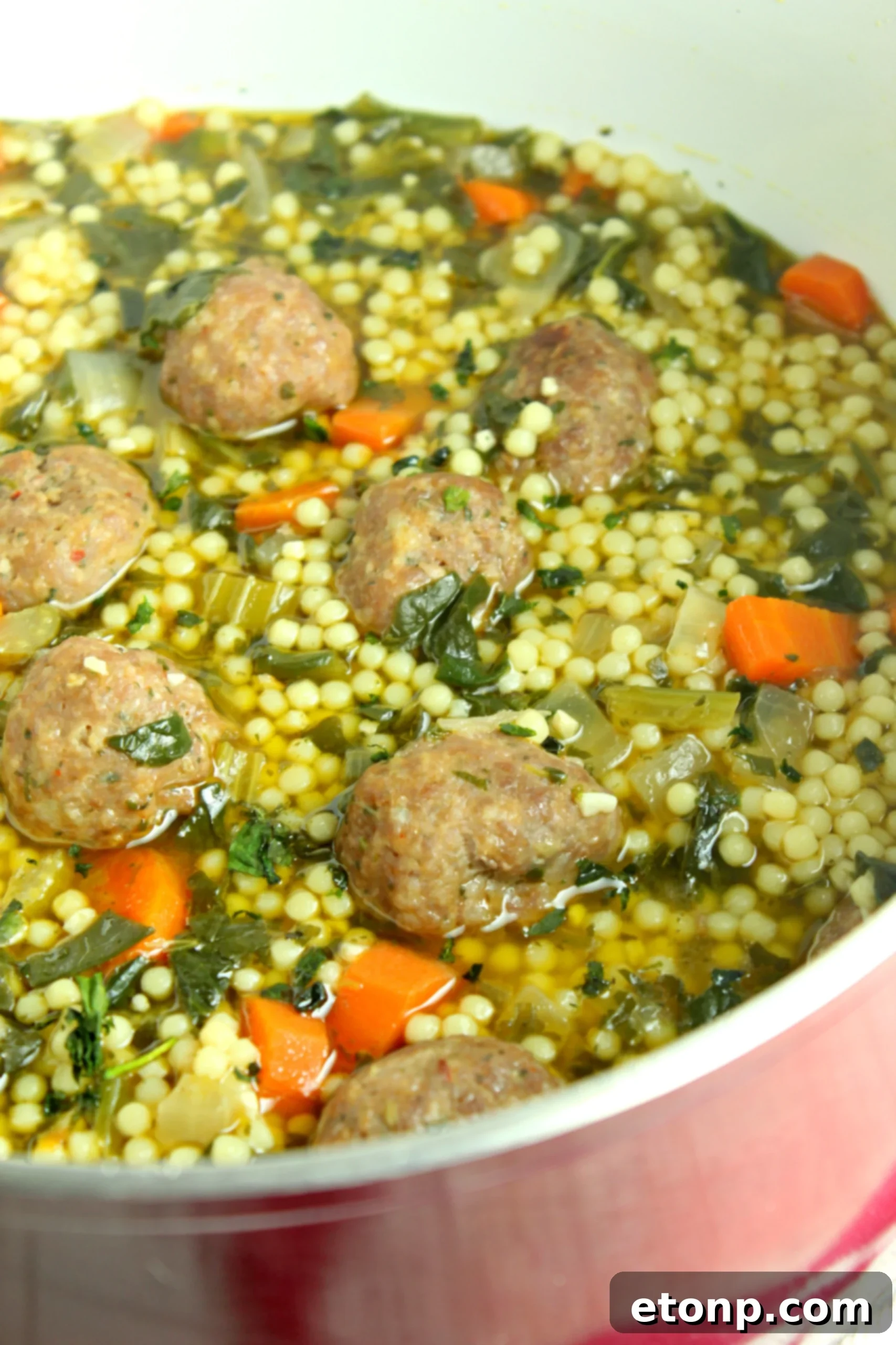 An overhead shot of Italian Wedding Soup in a bowl, showcasing its rich texture and appetizing presentation.