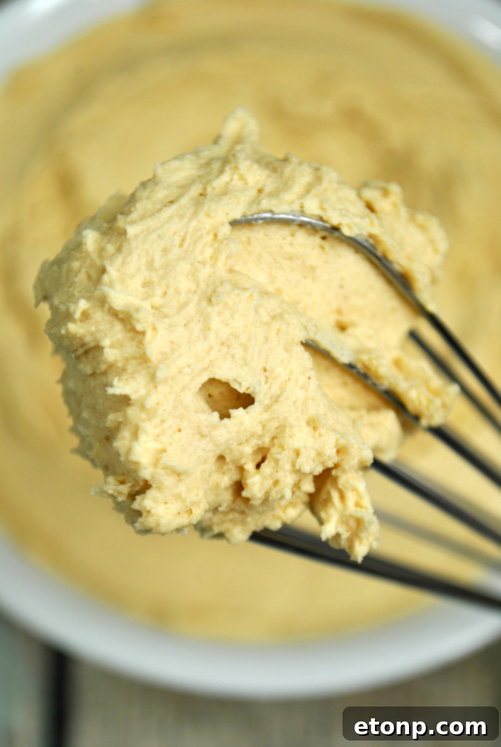 Deliciously smooth and creamy peanut butter frosting piped onto a cupcake, ready to be enjoyed.