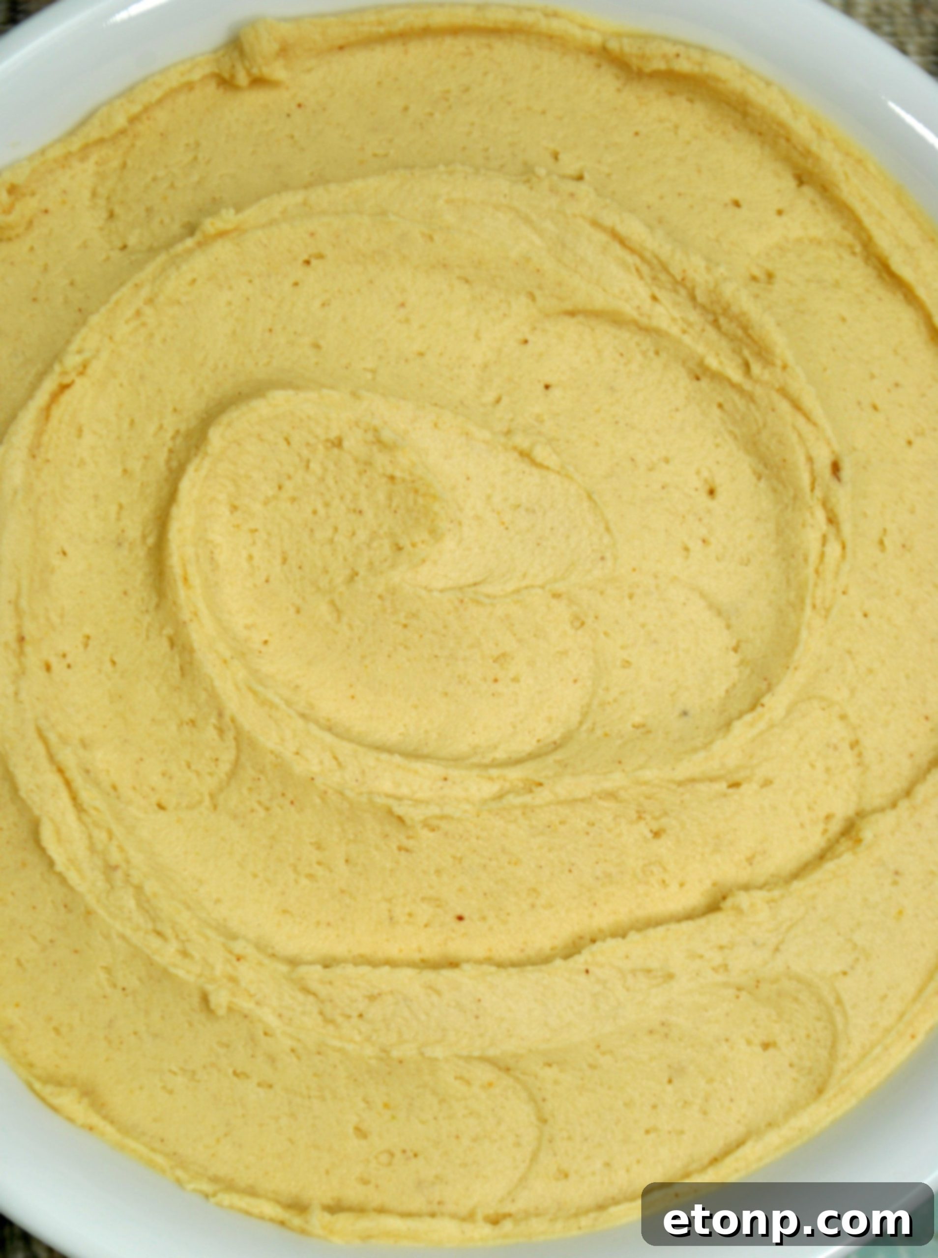 A bowl filled with freshly made, fluffy peanut butter frosting, ready to be used.