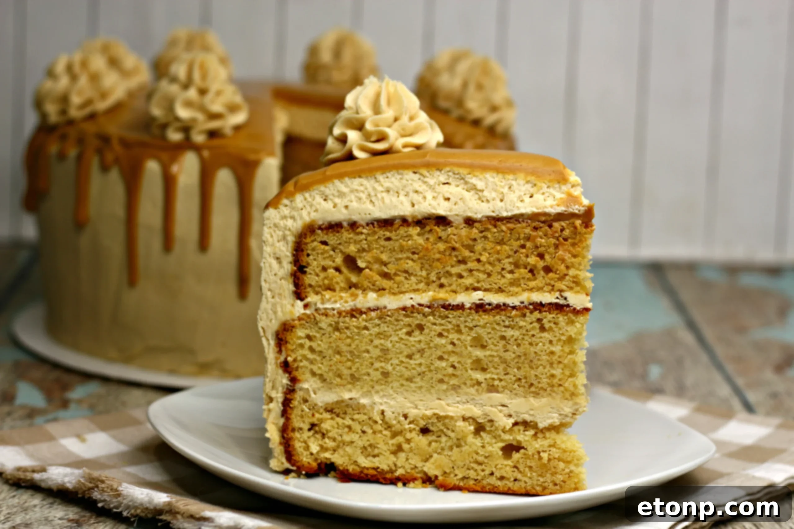 Sinfully Good Peanut Butter Cake 12 The complete peanut butter layered cake, ready for serving, with a slice already removed.