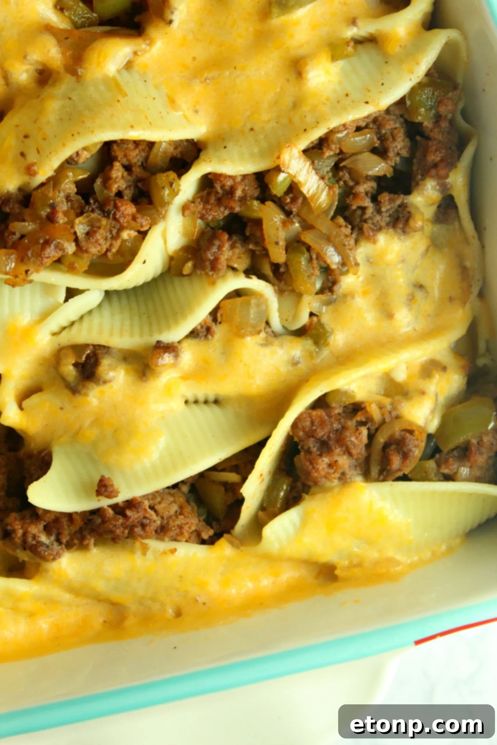 Close-up of golden brown Philly Cheese Steak Stuffed Shells, garnished with fresh parsley.