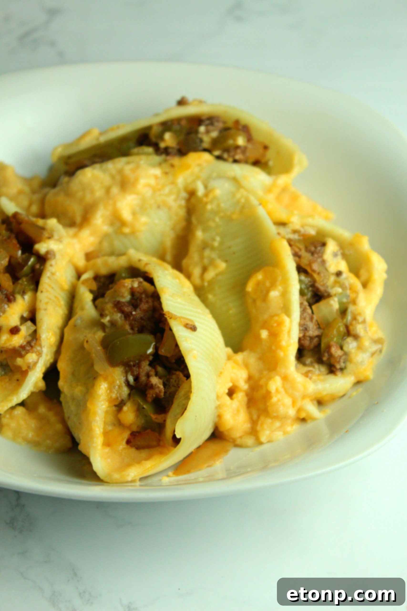 A close-up of a single Philly Cheese Steak Stuffed Shell, showing the rich filling and melted cheese.