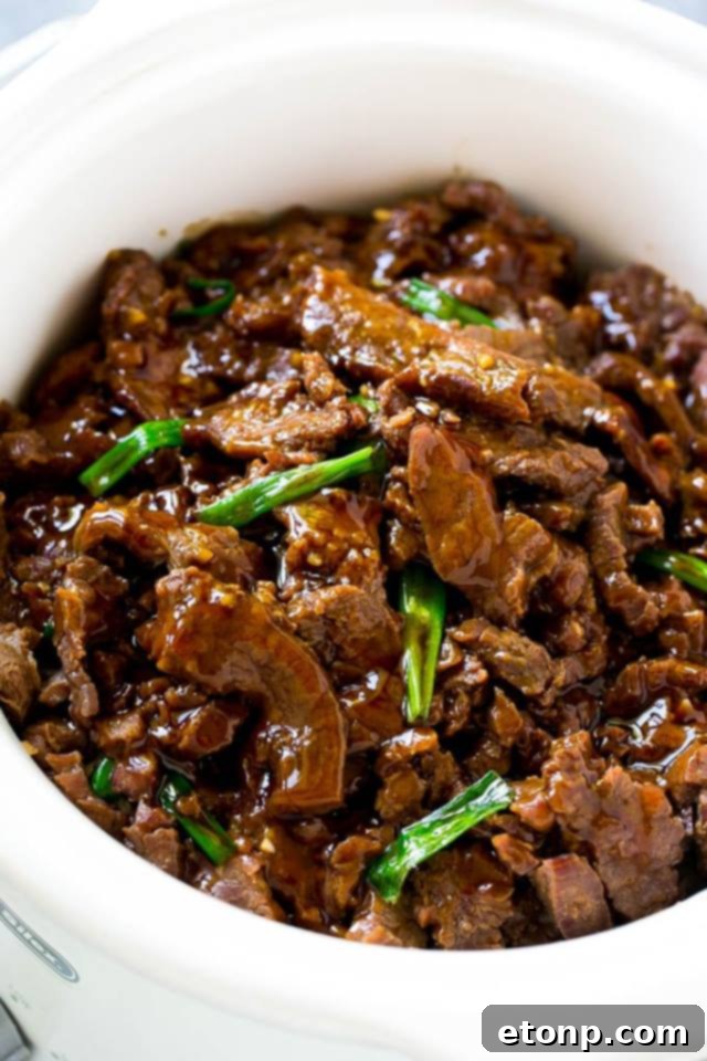 Slow Cooker Mongolian Beef served with rice and green onions