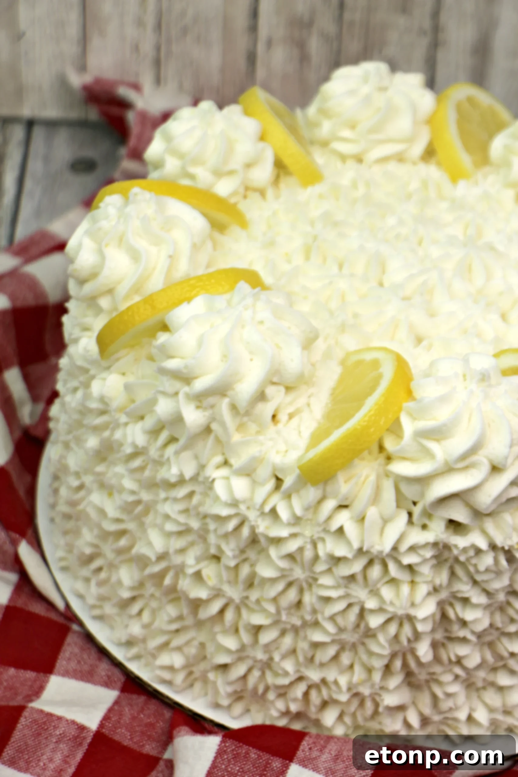 Close-up of a slice of Italian Lemon Drop Cake revealing its moist, yellow crumb and creamy lemon buttercream layers.