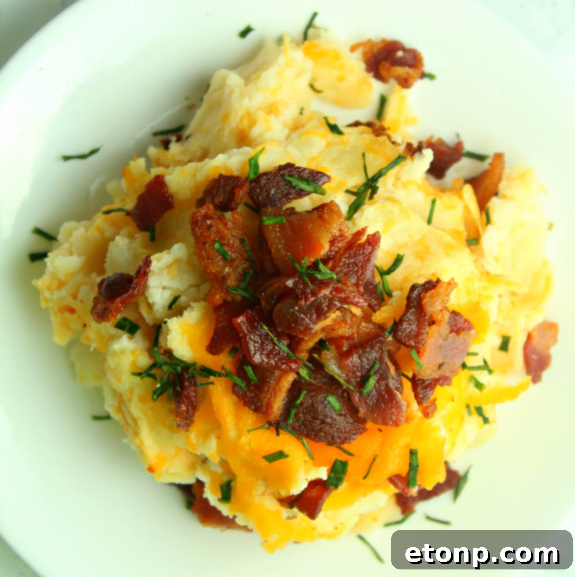 Ultimate Loaded Mashed Potato Casserole 5 Mashed potatoes being mixed with creamy ingredients like butter and sour cream, showcasing their smooth texture.