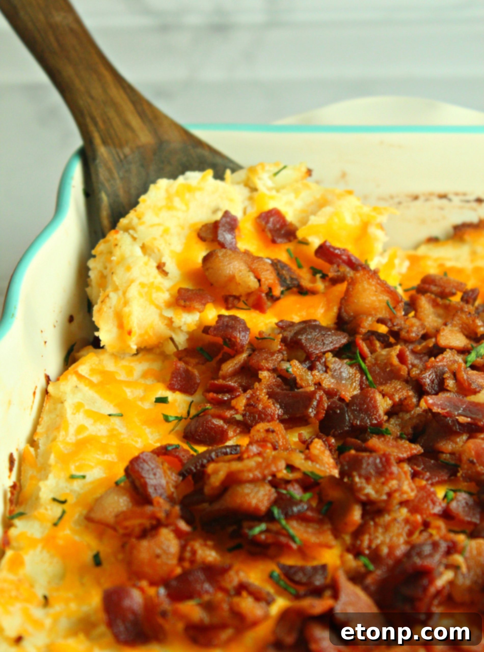Ultimate Loaded Mashed Potato Casserole 6 Loaded Mashed Potato Casserole, freshly baked and garnished, ready to be served at a gathering.