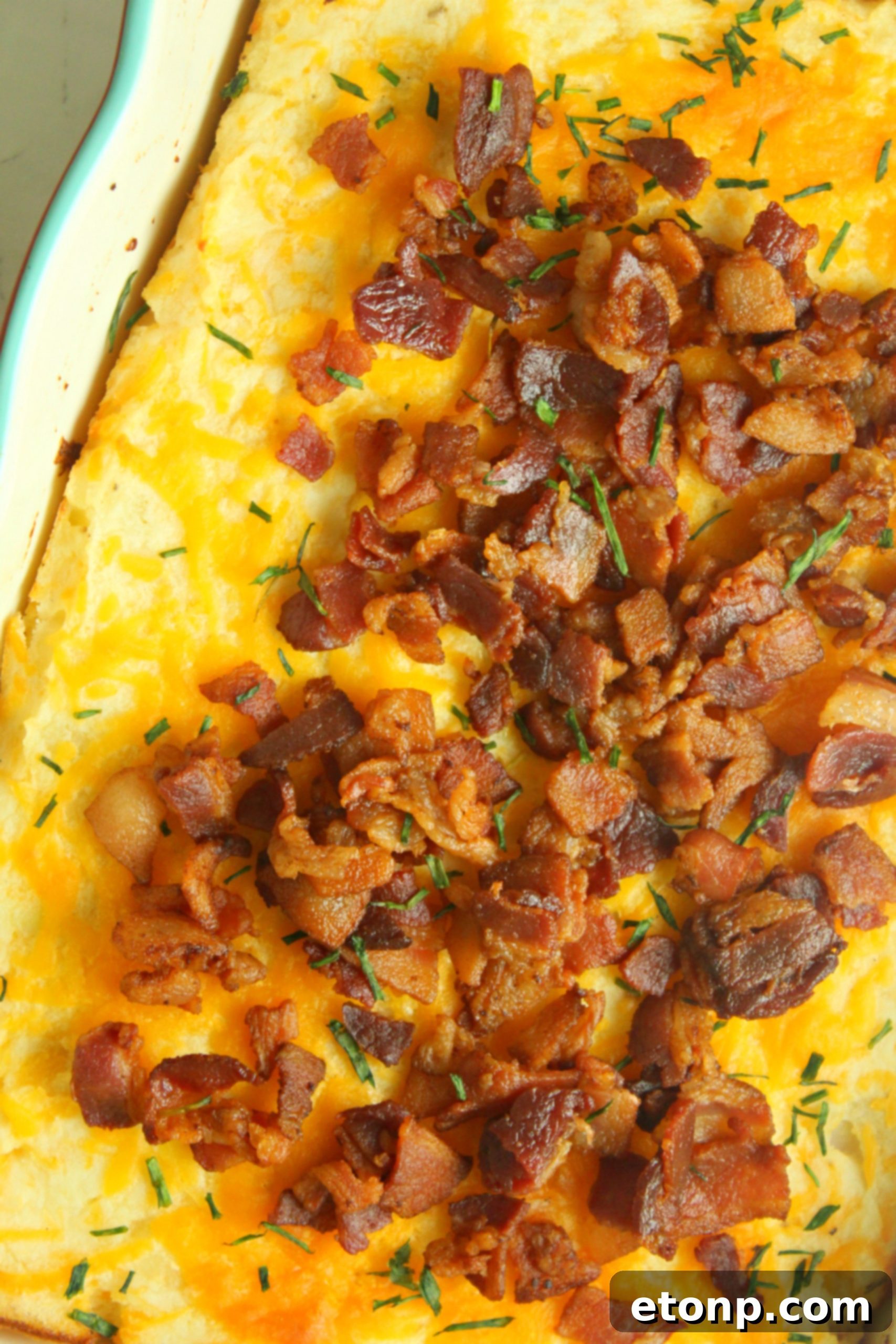 Ultimate Loaded Mashed Potato Casserole 8 A full casserole dish, beautifully baked and garnished with green onions and fresh parsley.