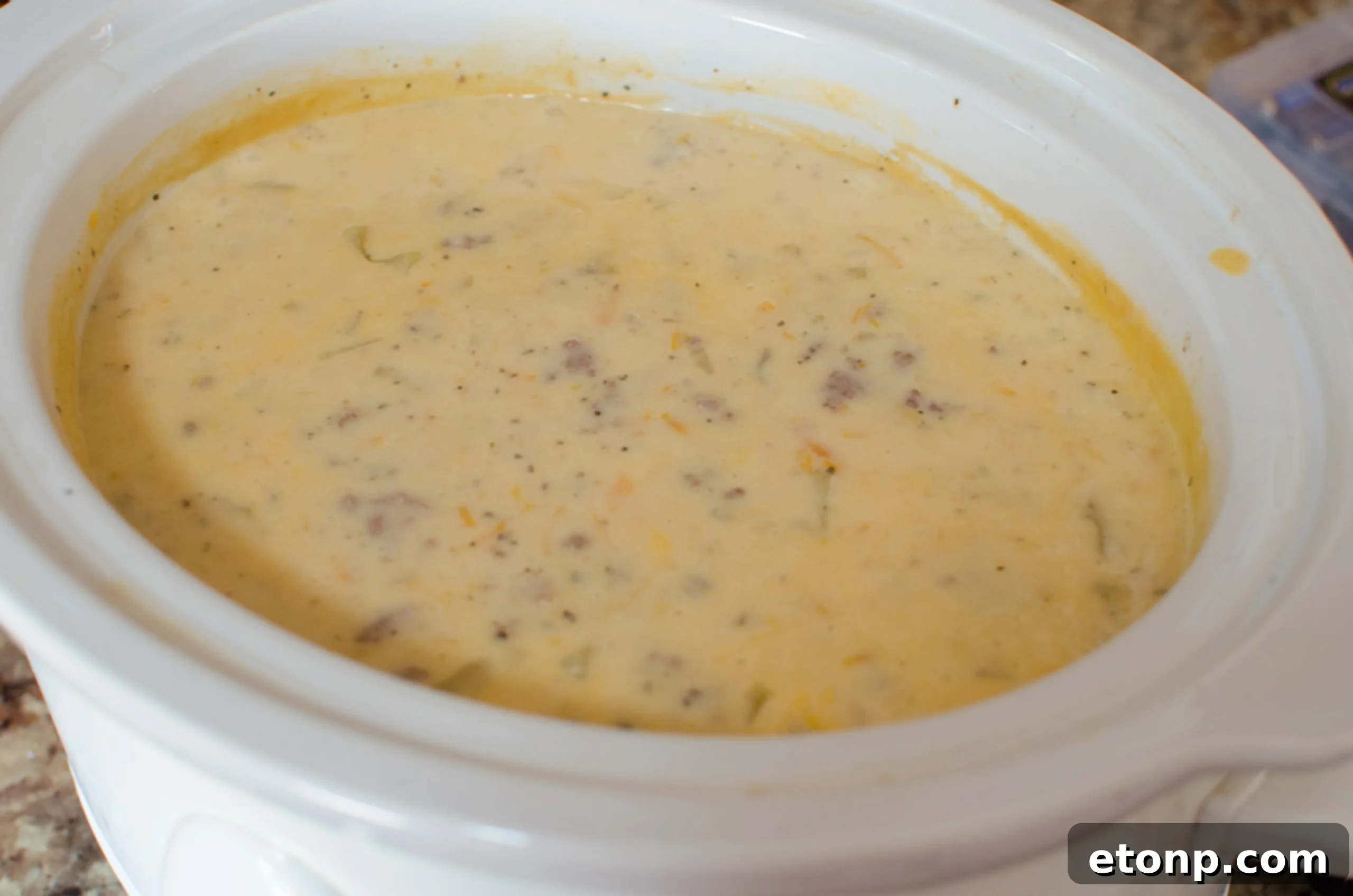 A beautifully presented bowl of Slow Cooker Cheeseburger Soup with a side of crusty bread, ready for serving.
