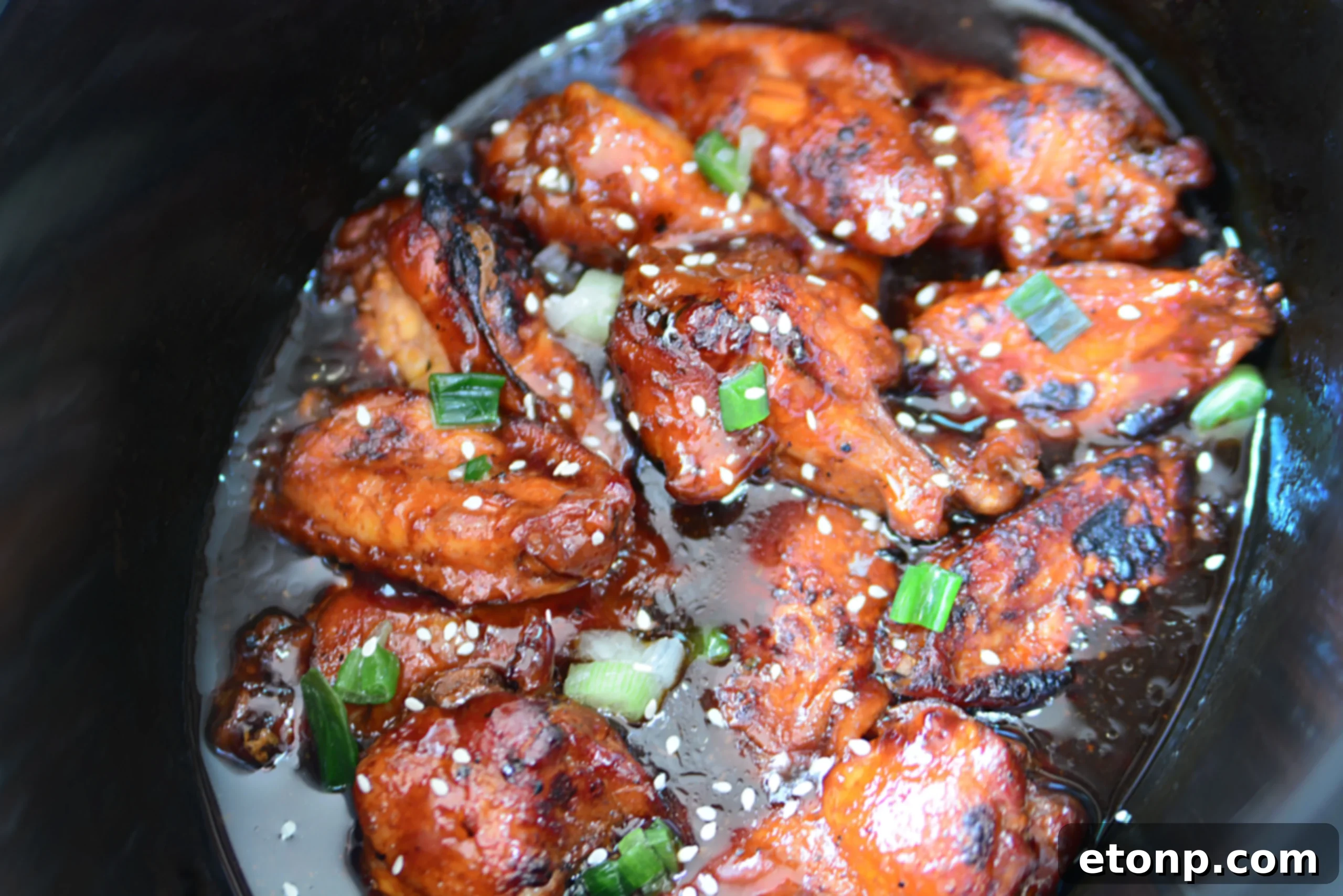 Assortment of football-themed snacks and appetizers including chicken wings for a Super Bowl party