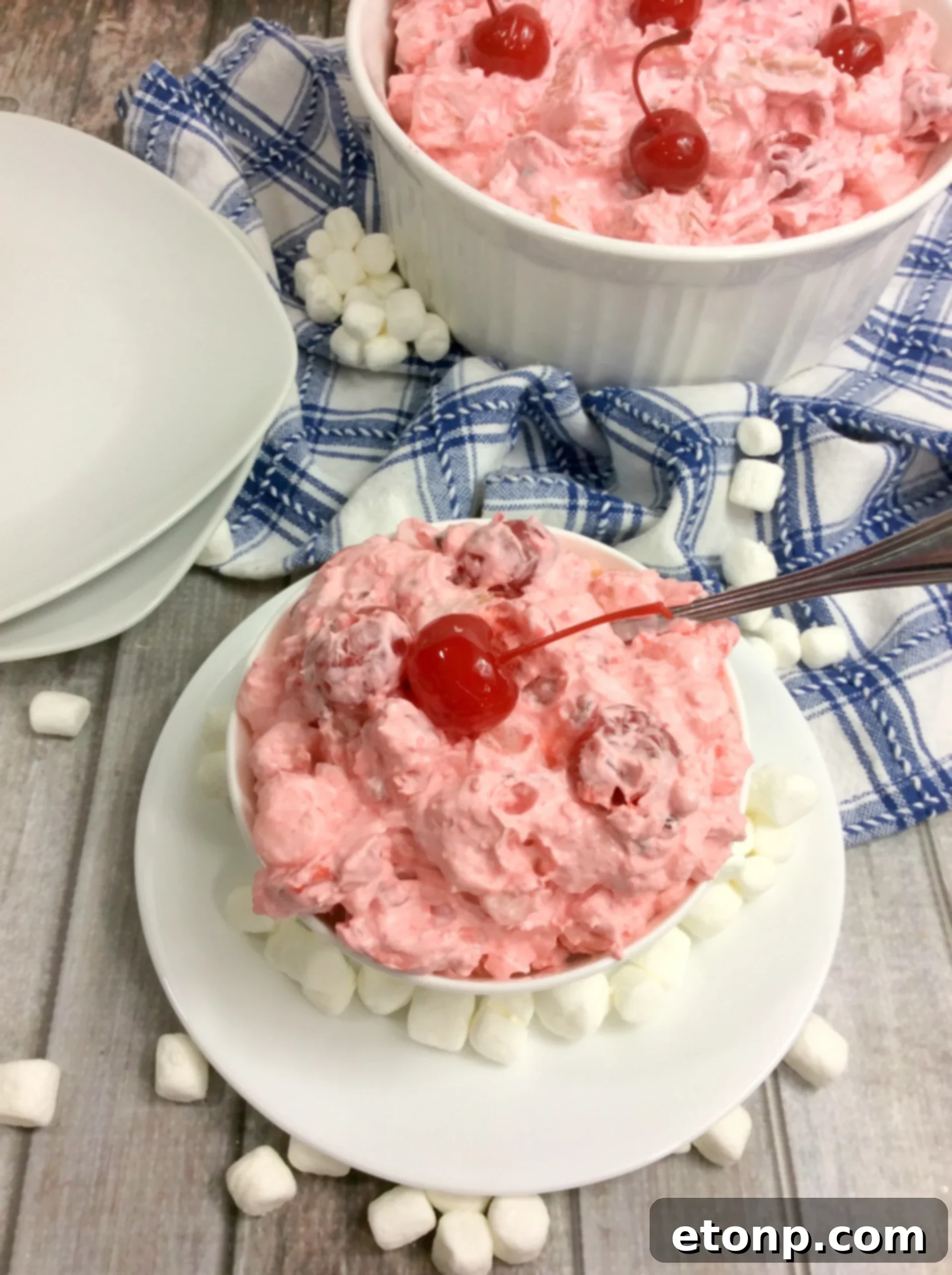A large serving bowl filled with Cherry Fluff Salad, showcasing its readiness for a gathering.