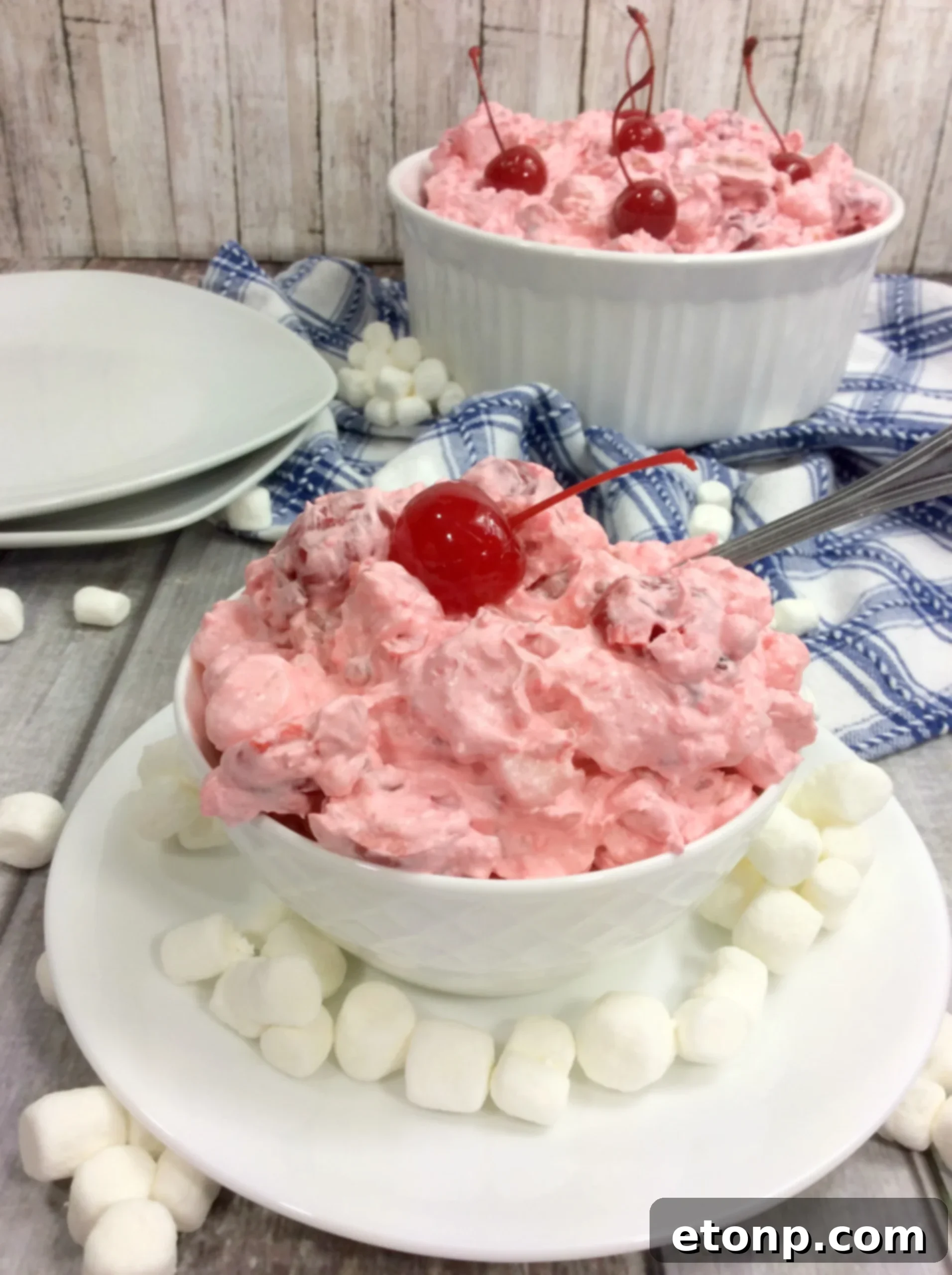 A spoonful of Cherry Fluff Salad being lifted from the bowl, demonstrating its light and airy consistency.