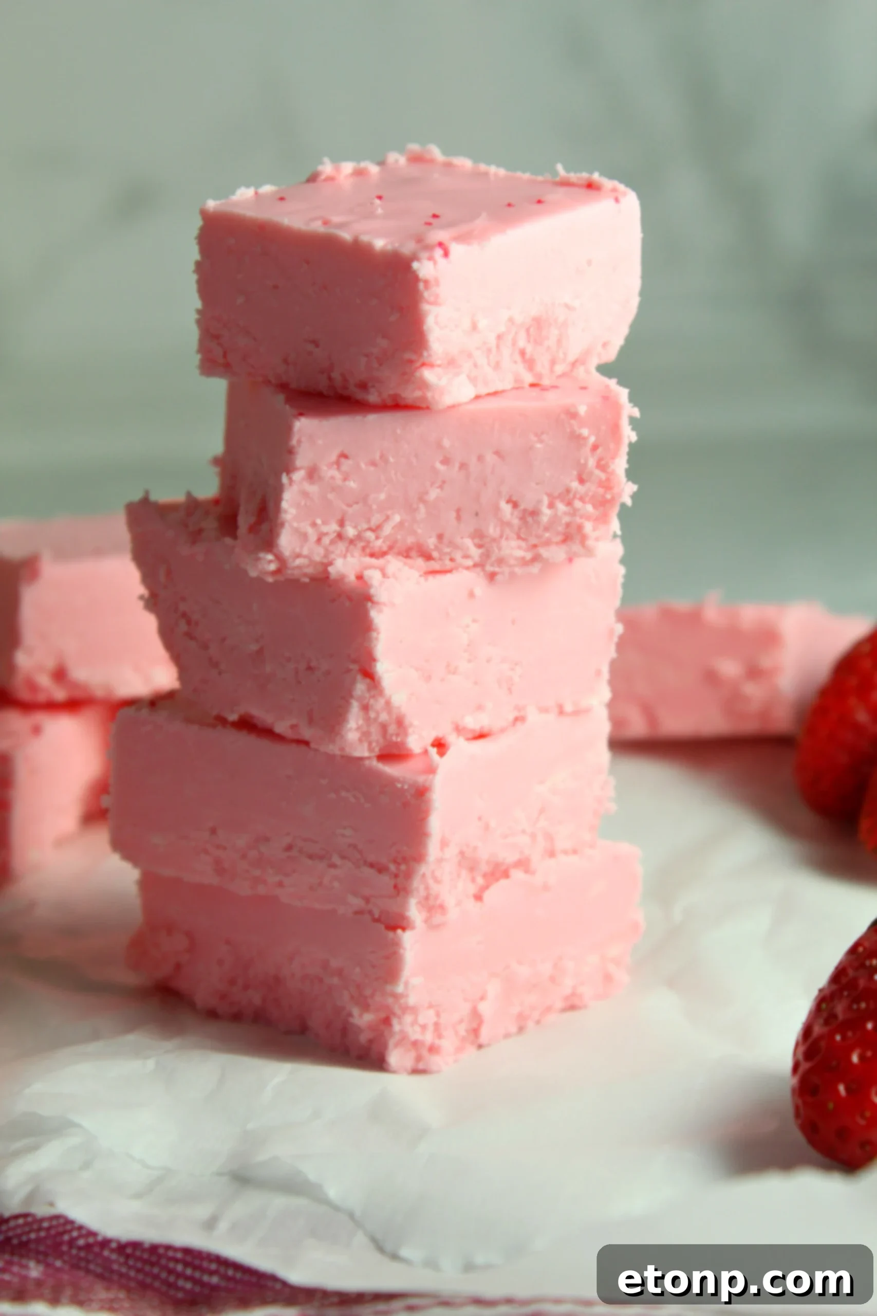 Effortless Strawberry Two-Ingredient Fudge 2 Deliciously pink strawberry no-bake fudge squares on a plate