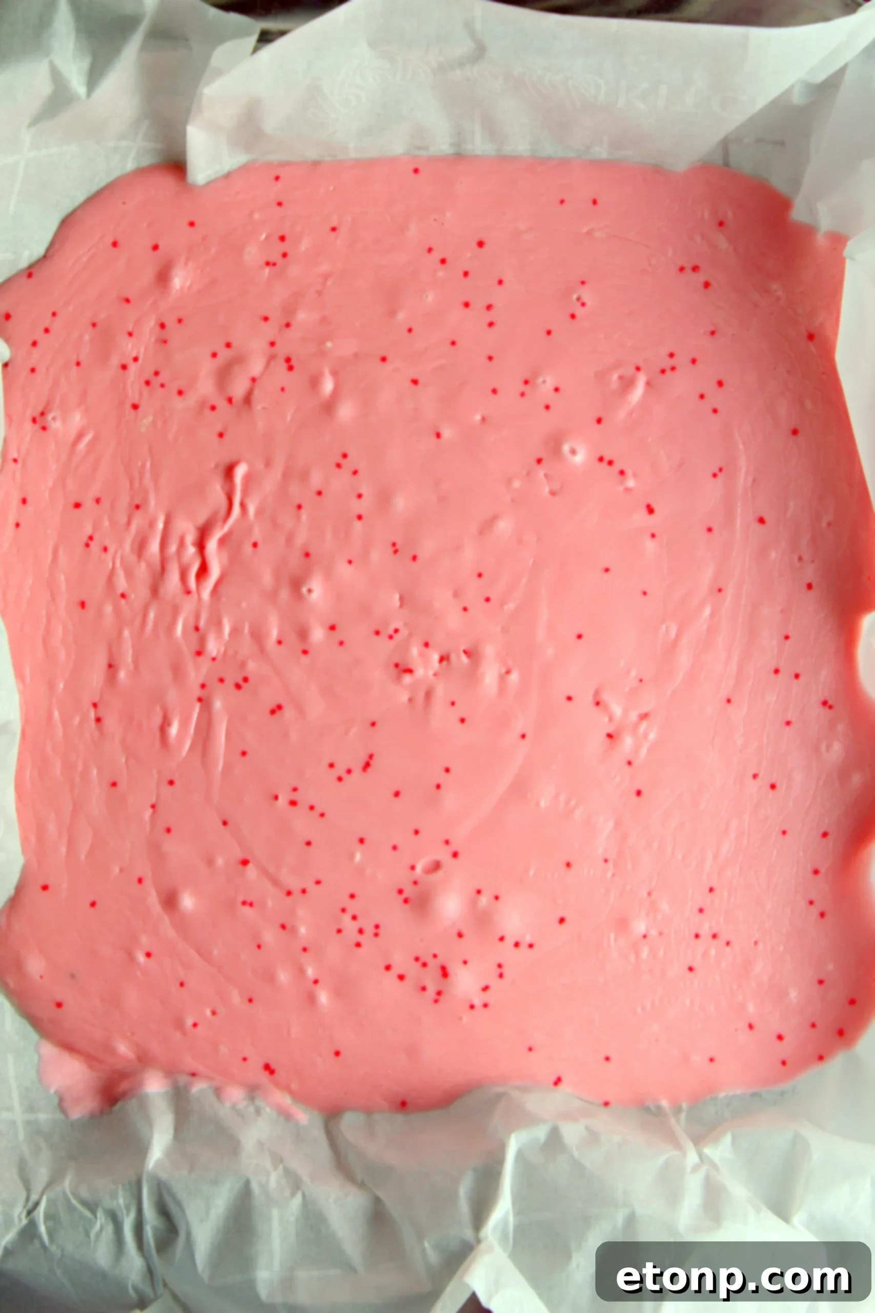 Effortless Strawberry Two-Ingredient Fudge 3 Close-up of a hand holding a piece of strawberry no-bake fudge