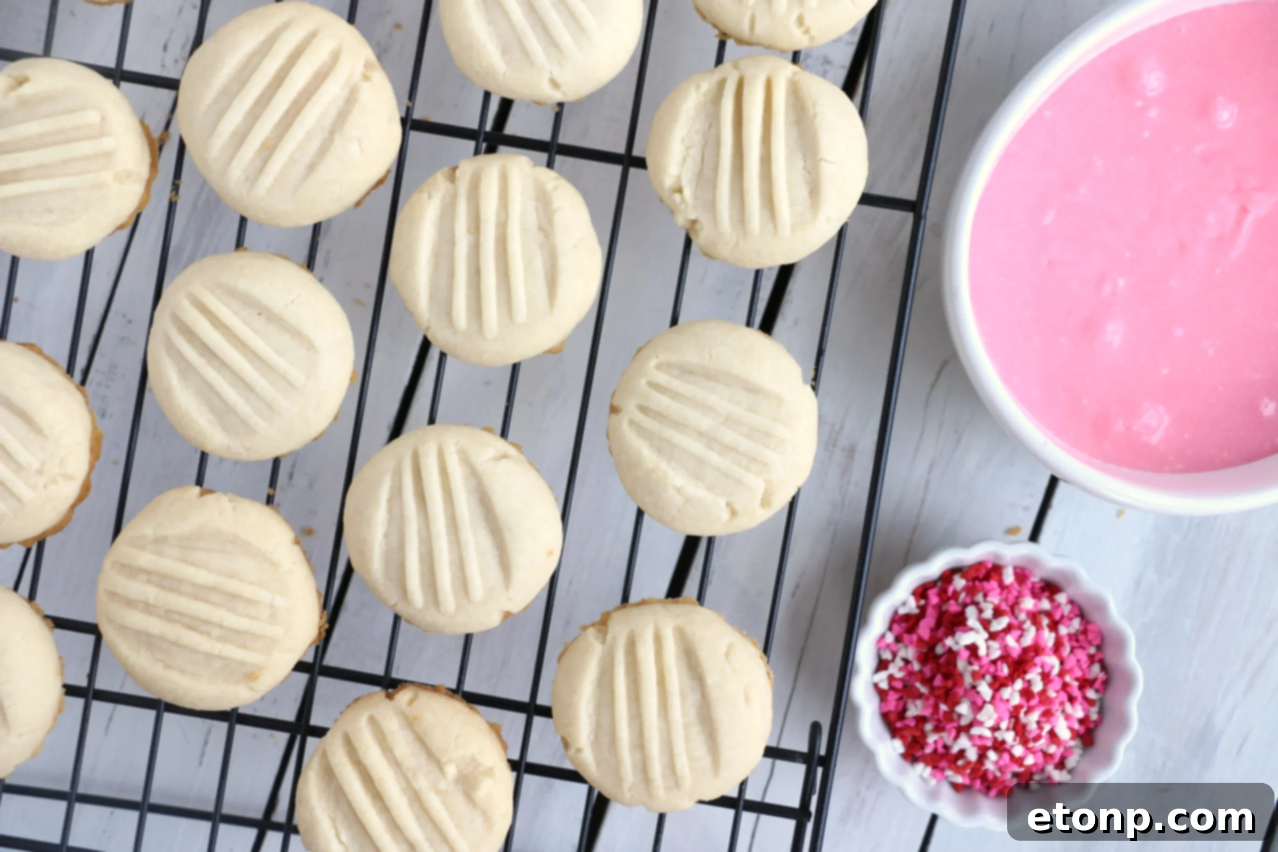 Velvet Vanilla Frosted Delights 3 Close-up of a batch of freshly baked Melt-Away Vanilla Frosted Cookies with a smooth vanilla glaze.