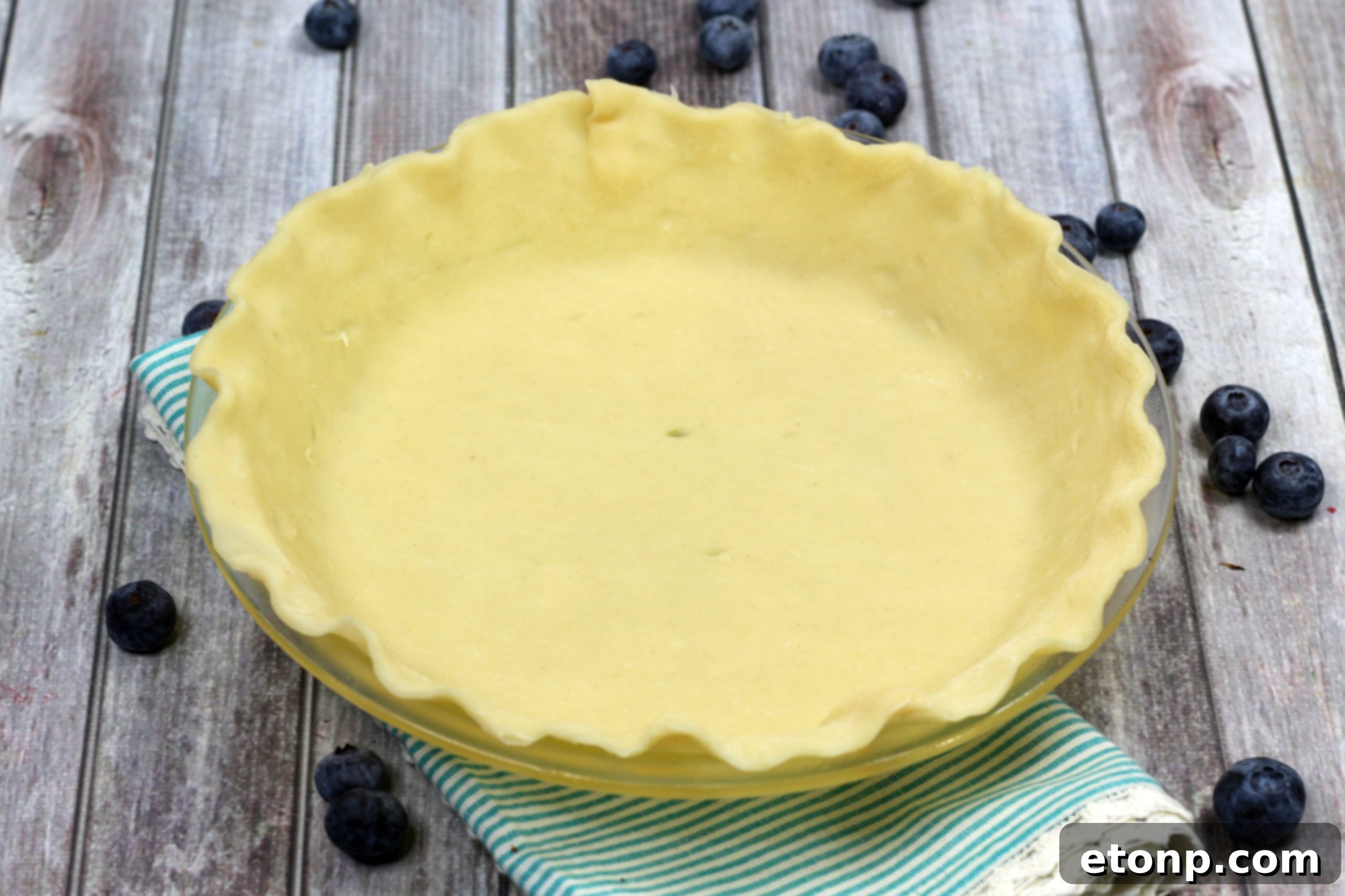 A baked blueberry pie with a golden, intricately woven lattice crust
