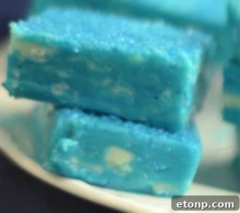 Assortment of pastel-colored fudge squares, including pink, blue, and white, arranged for a celebratory display