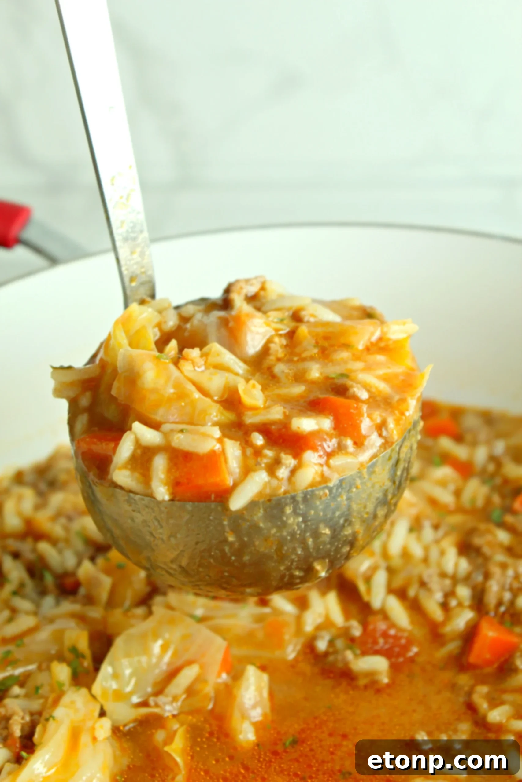 A large pot of cabbage roll soup simmering on the stove, showing the vibrant colors of the ingredients.